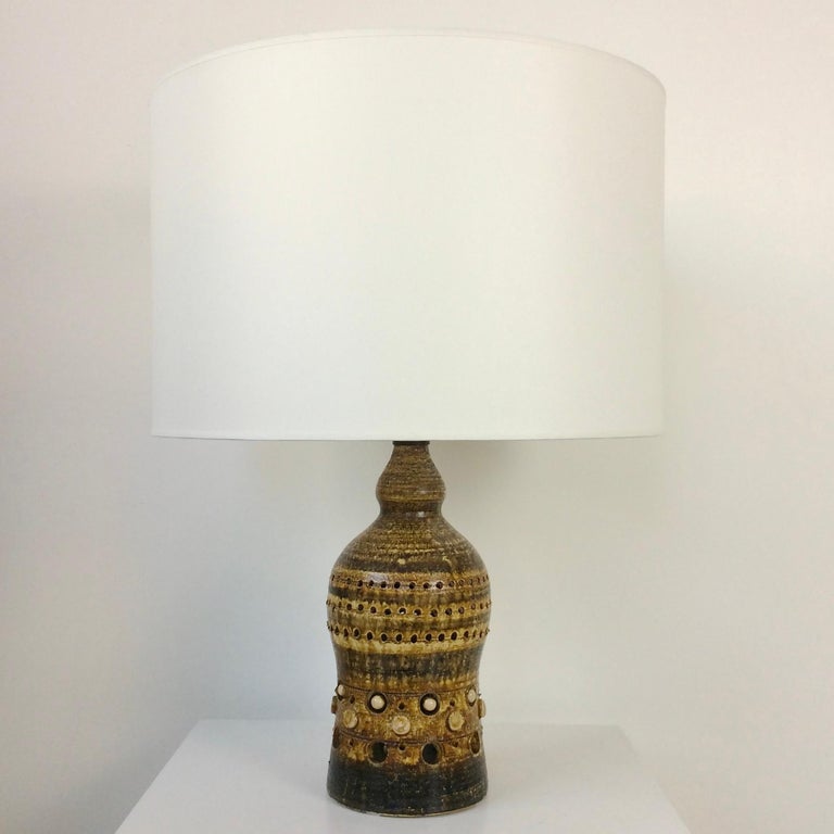 Georges Pelletier table lamp, circa 1970, France.
Brown incised and hand painted ceramic.
New white fabric shade. Rewired.
One E 27 bulb of 60W and one E22 bulb of 15 W inside the ceramic.
Dimensions: 61 cm total height, diameter: 44 cm. 
Good