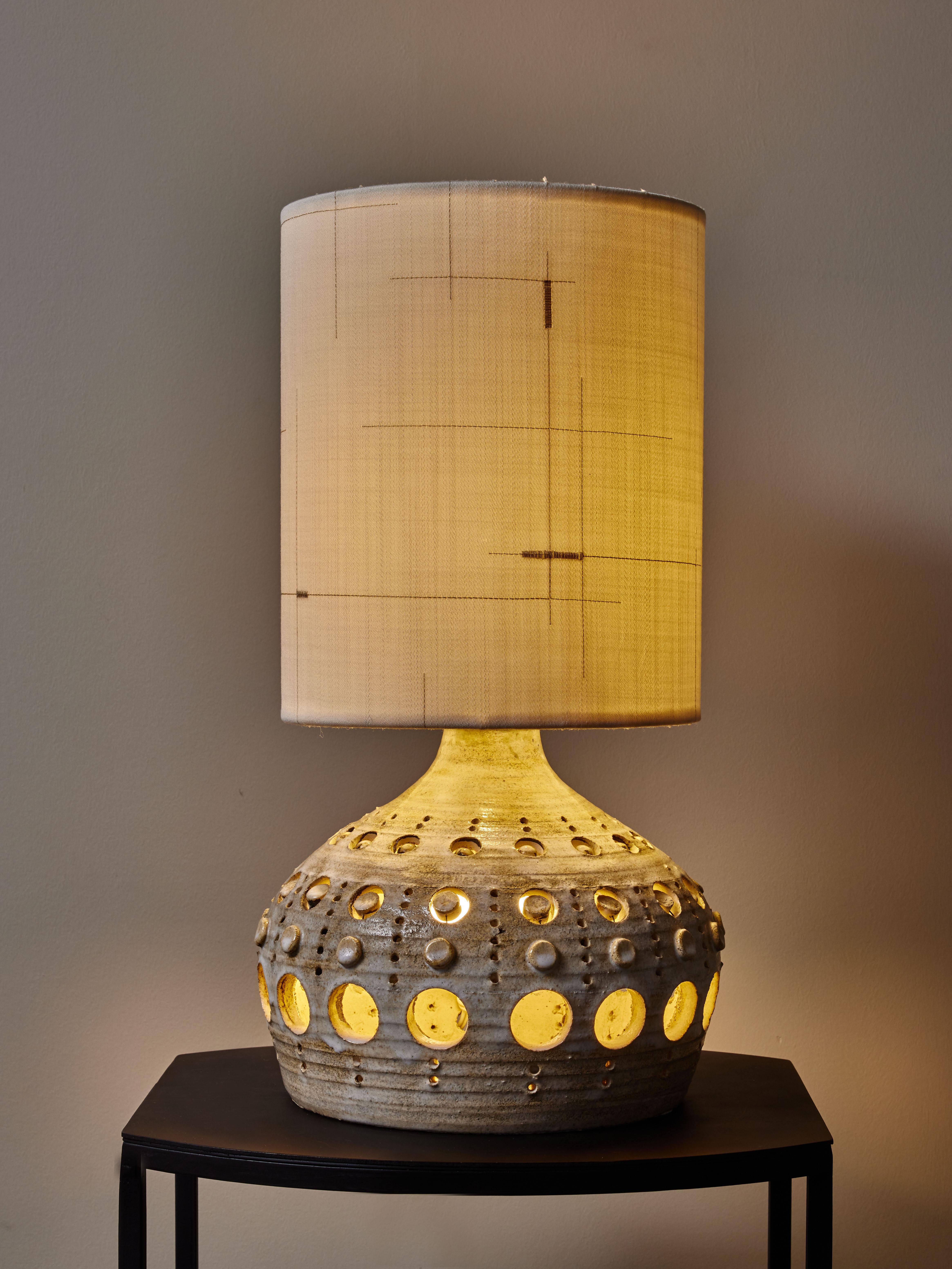 Round white and brown glaze ceramic table lamp by Georges Pelletier with see through decors. 
Georges Pelletier
Born in 1938 in Brussels, Belgium, Georges Pelletier is a ceramist who lives and works in Cannes, France. His ceramics are highly sought