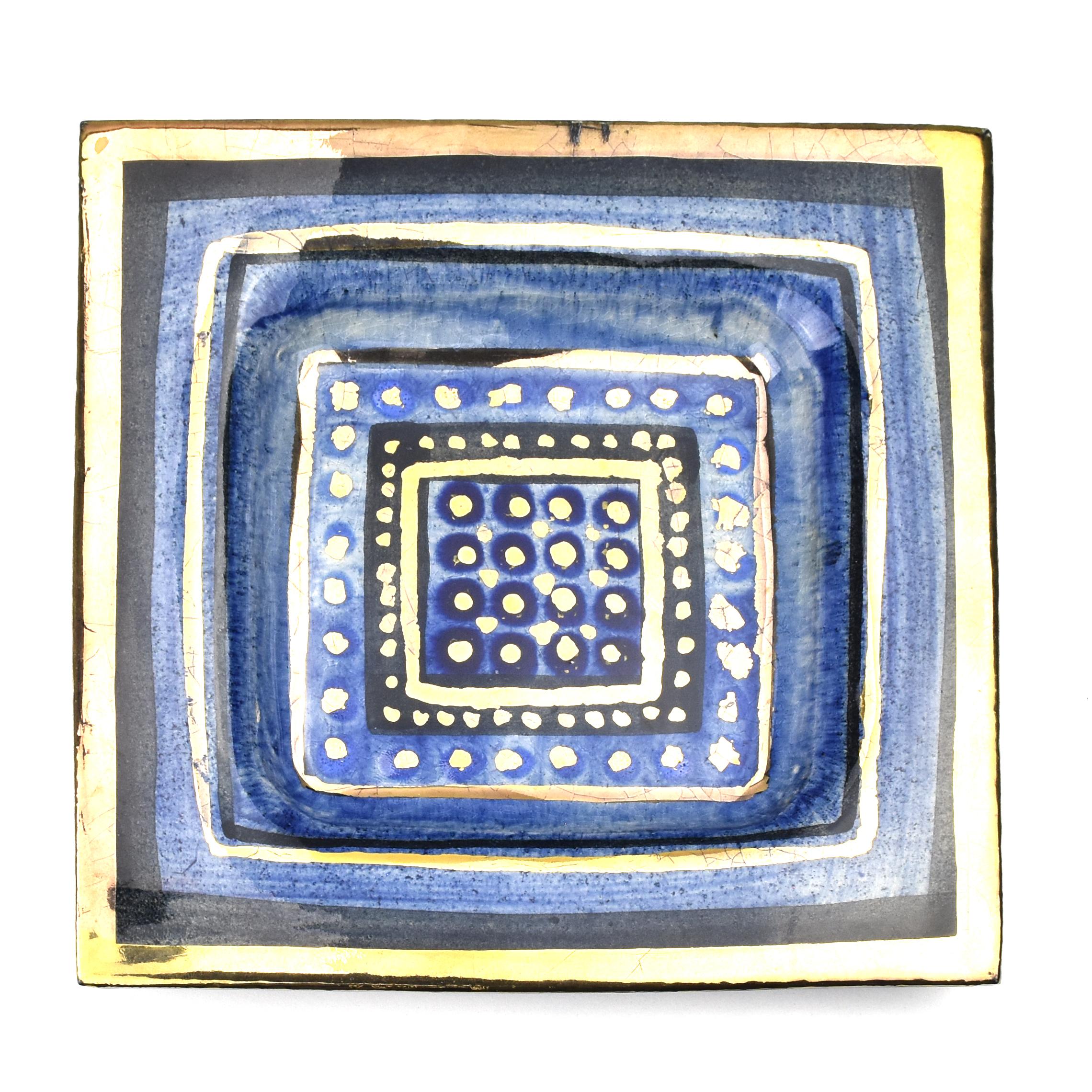 Plat décoratif en céramique ou vide-poche du céramiste Georges Pelletier, France.

Bol en céramique fabriqué à la main, avec un design attrayant dans les tons de bleu avec des lignes noires et des détails dorés et une finition brillante. Monté avec
