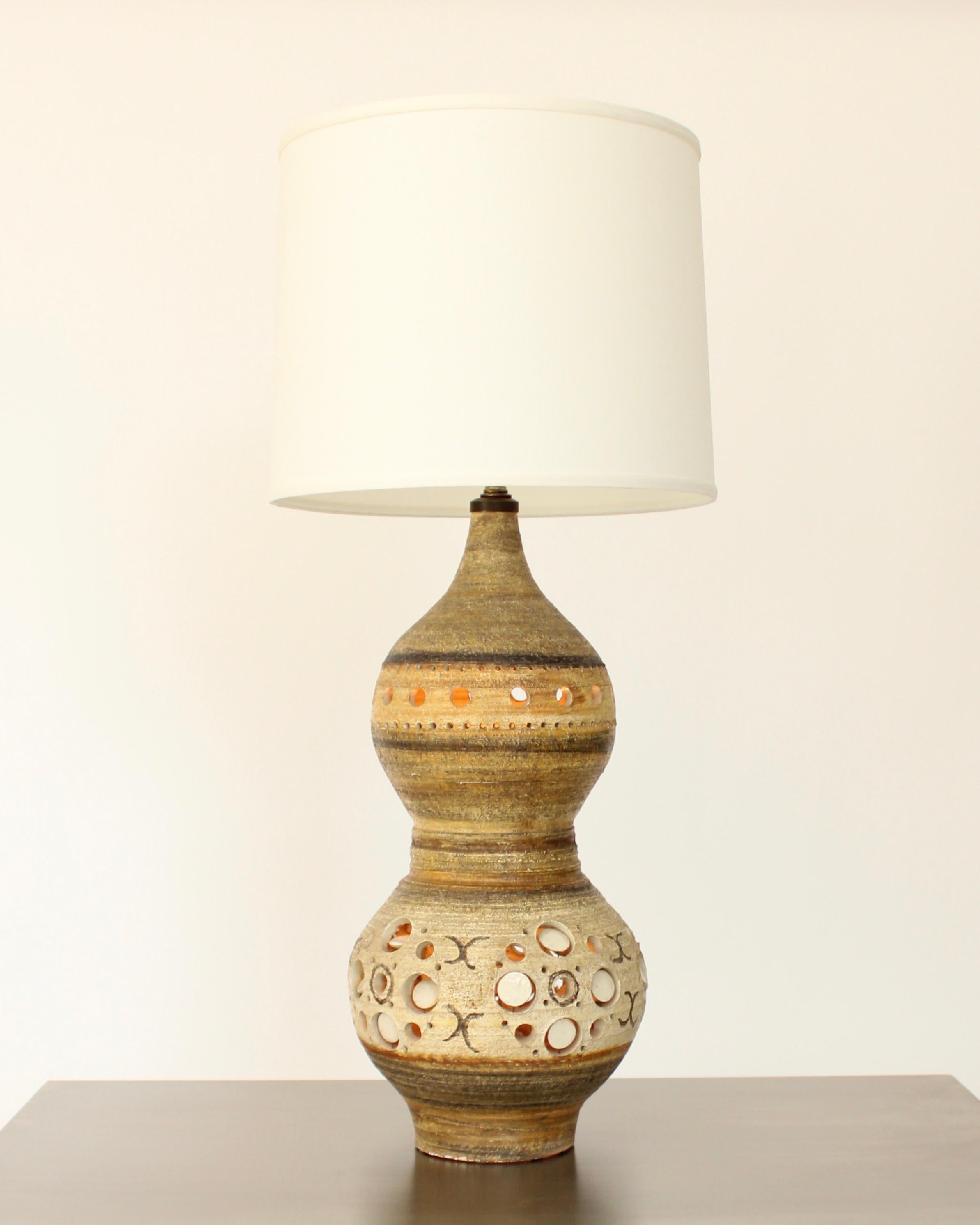 Georges Pelletier French ceramic double gourd form table lamp. 
This lamp has the iconic piercings into the clay with round disks. Light can emirate through the round piercings. 
This is an early lamp with lovely hand painted moon forms and warm
