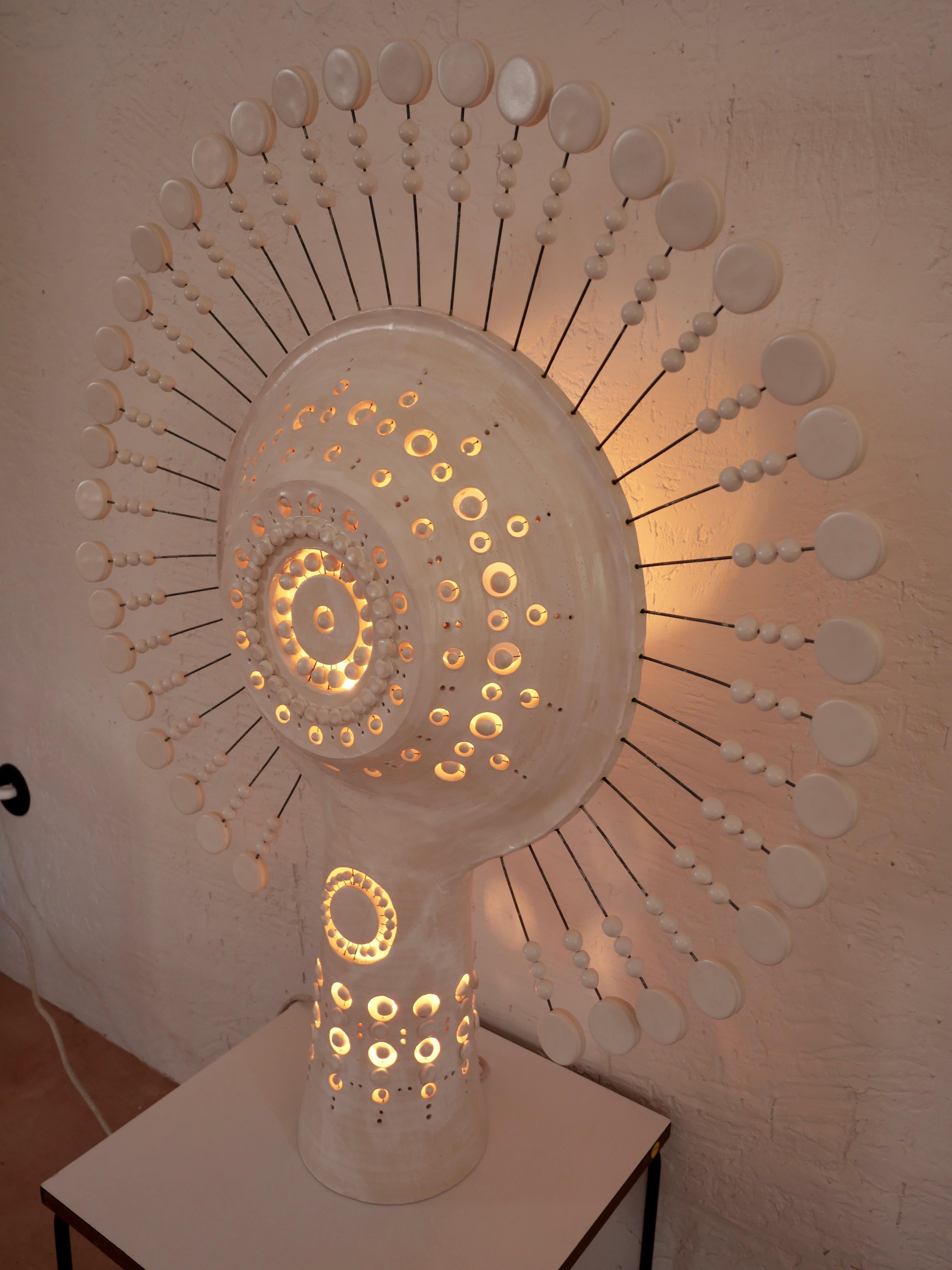 Georges Pelletier Sonnenlampe aus weiß emaillierter Keramik, eine skulpturale Steh- oder Tischleuchte, die in der Nacht ein erstaunliches Lichterlebnis und tagsüber eine beeindruckende skulpturale Präsenz in Ihren Raum bringt. Ungefähre Maße: Höhe