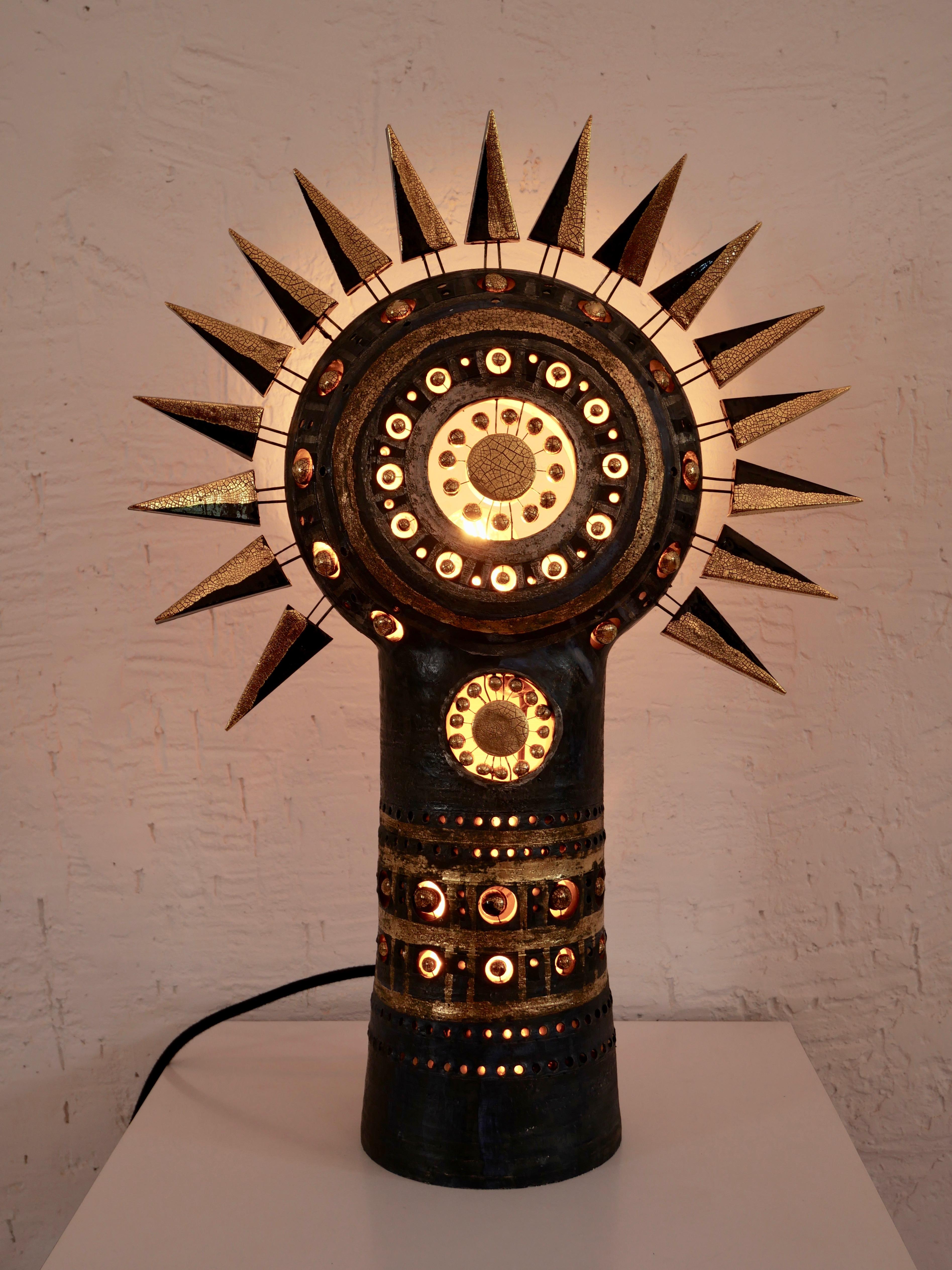 Sun table lamp in bluish black gold & Platine enameled ceramic, table lamp bringing to your space an amazing light experience when the night falls, and a stunning sculptural presence during the day. Approximate dimensions height 55 cm x width 38 cm.