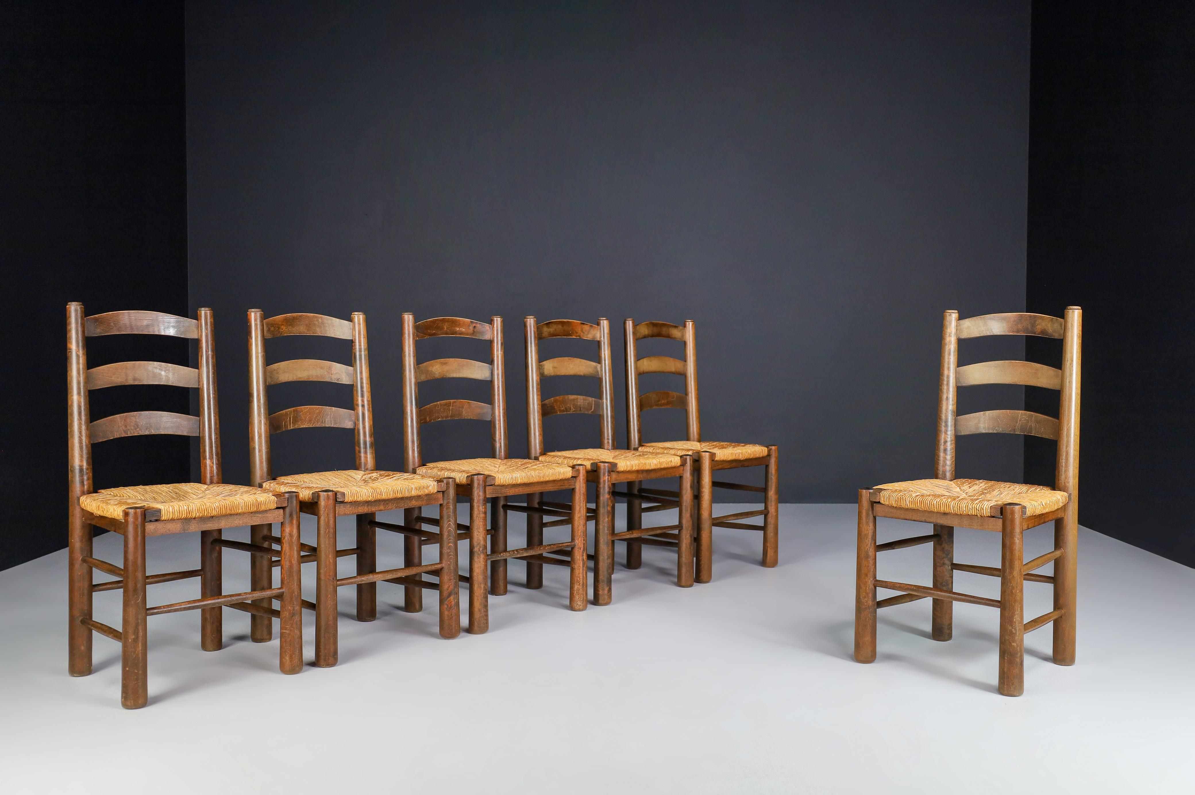 Georges Robert dining chairs in oak and rush, France 1950s

Set of 6 Mountain or chalet chairs made by Meubles Georges Robert french cabinetmaker in the 1950s. The structure is of solid oak with conical legs. The seat is woven rush, reminiscent of