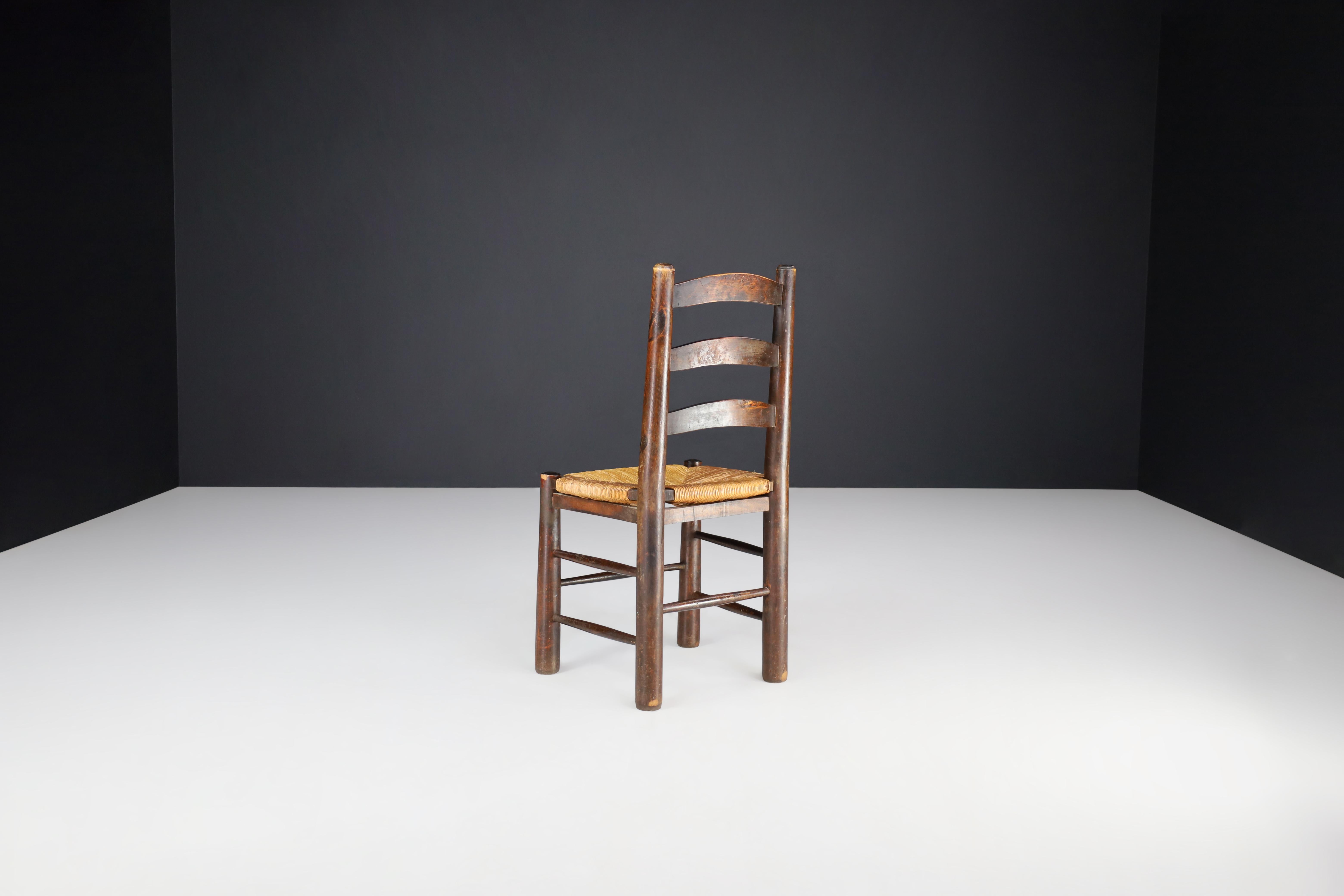 Brutalist Georges Robert Dining Chairs in Patinated Oak and Rush, France, 1950s For Sale