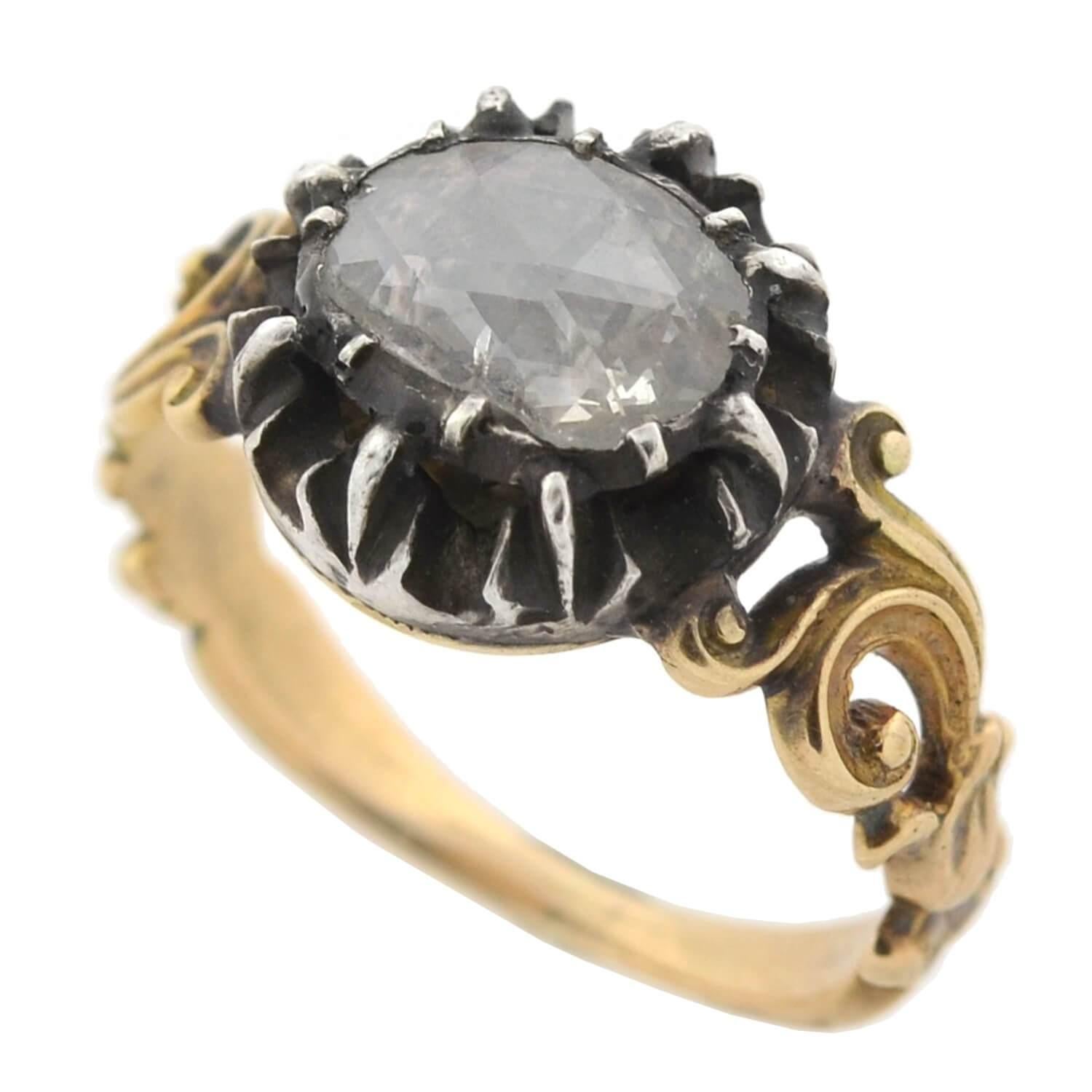 An exquisite old Rose Cut diamond ring from the Georgian era (ca1790)! This wonderful piece is crafted in 15kt yellow gold with a darkened sterling silver setting. A large, sparkling old Rose Cut diamond rests at the center, held within a closed
