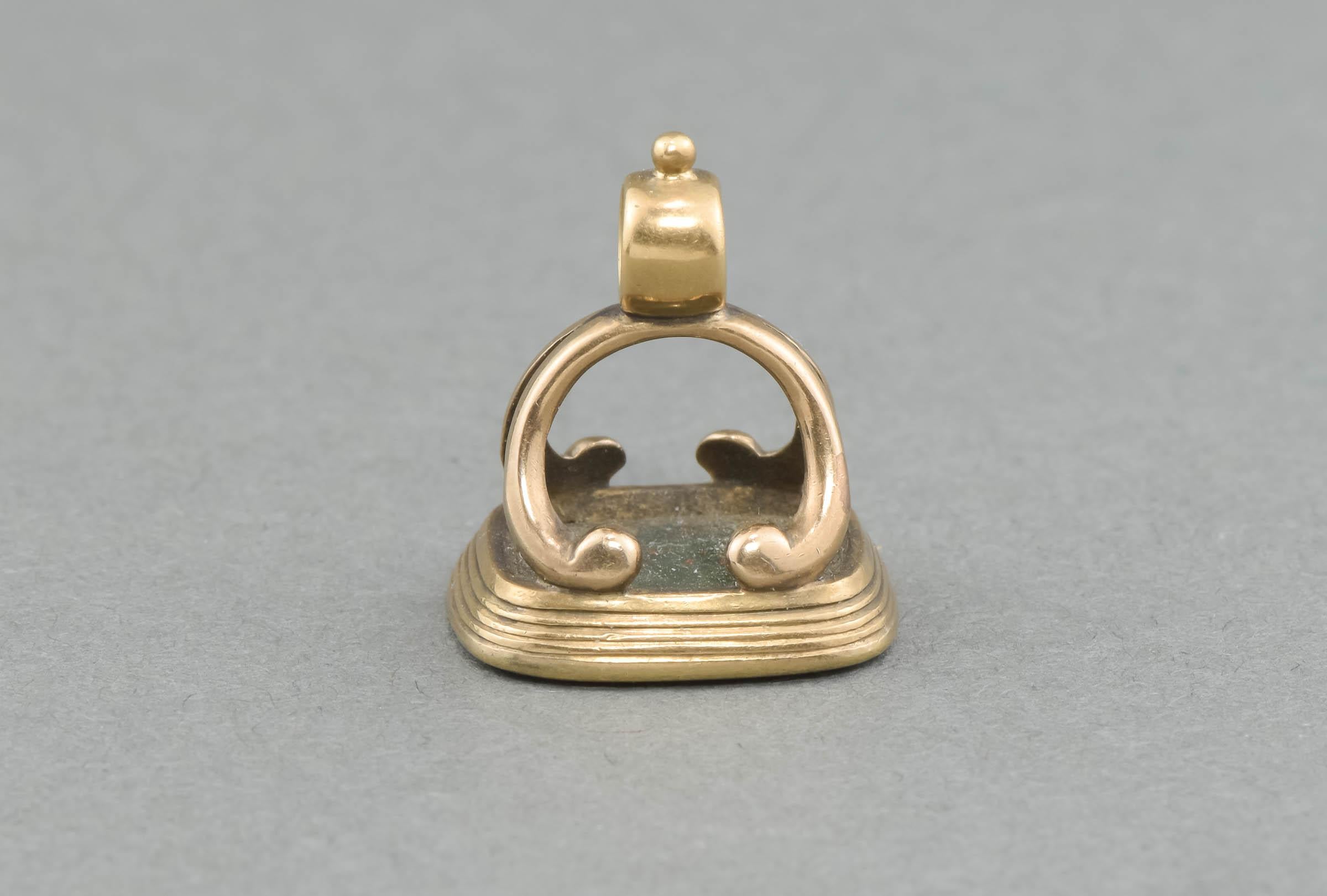 Crafted of solid 10K gold, the fob features a classic early design, with a still crisply carved bloodstone intaglio. The carving depicts a swan sitting on a crown, above the monogram or initials of 
