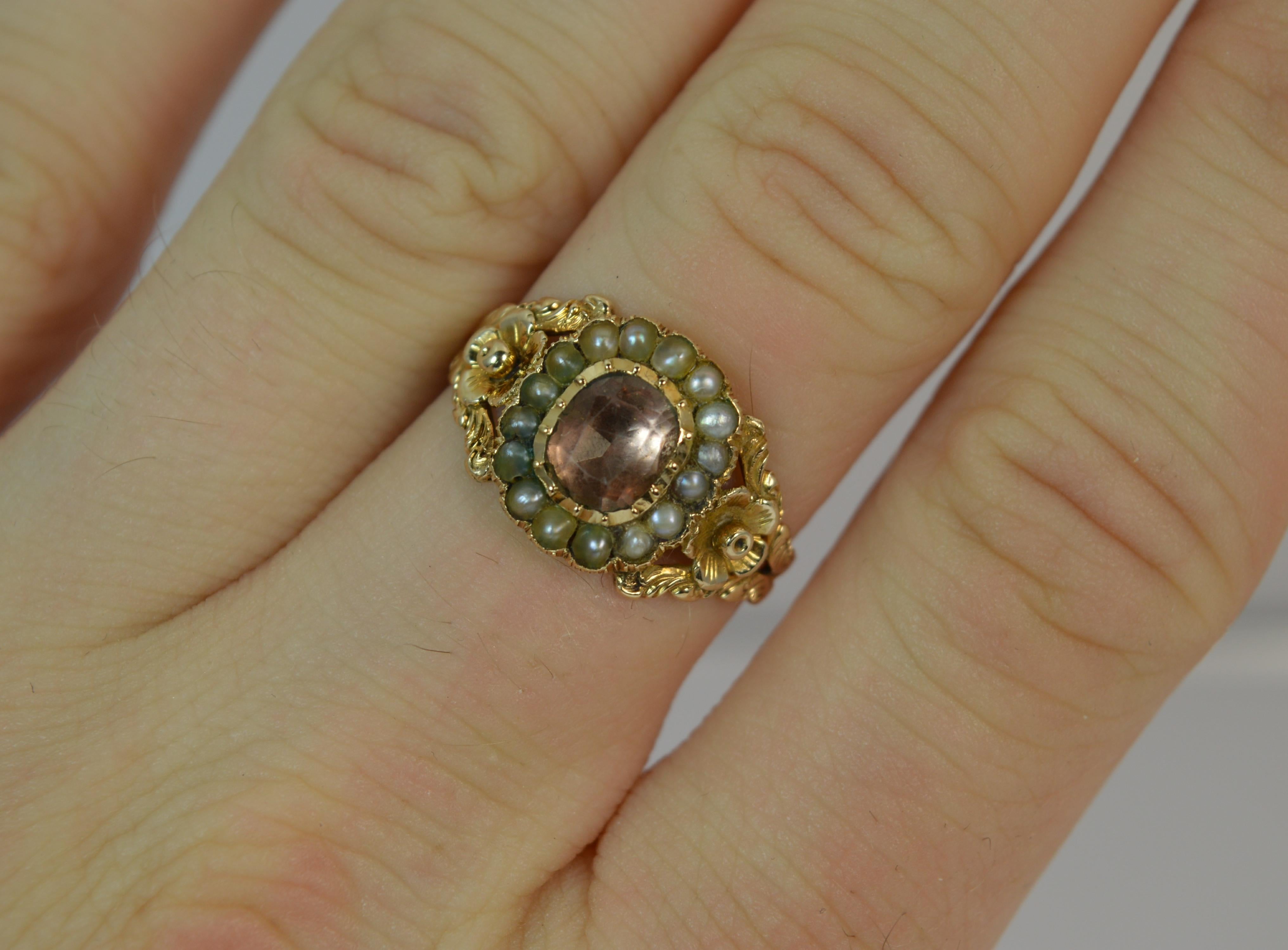 
A true Georgian period cluster ring. Solid 15 carat gold example.

​Designed with a foiled back rock crystal to the centre with a full seed pearl surround. 10mm x 12mm cluster head.

To the shoulders is a deep floral relief engraving.

A stunning