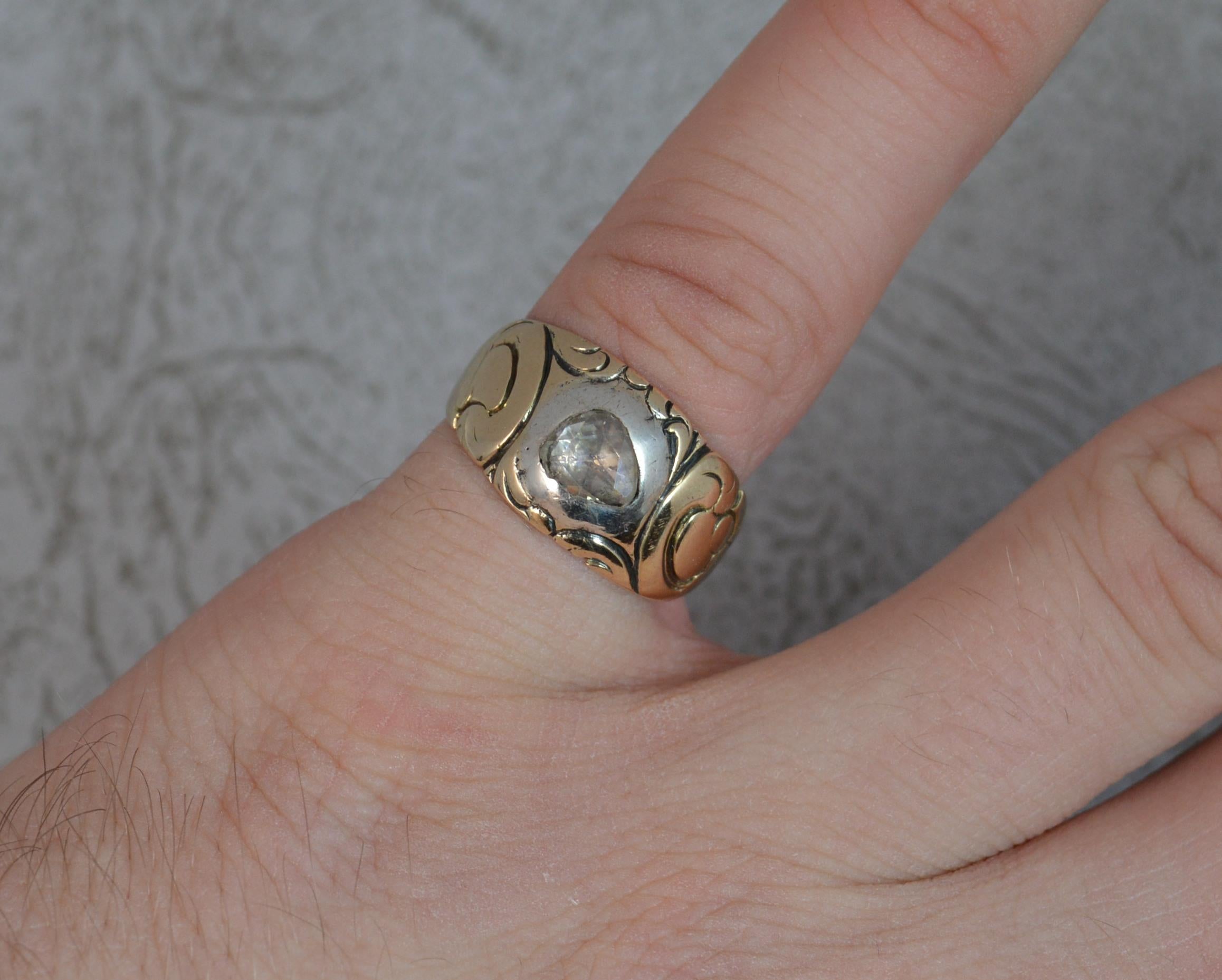 A very fine true Georgian period ring.
SIZE ; K UK, 5 1/4 US and sizeable
Designed with a single rose cut diamond in silver bezel setting and closed back. 5.2mm x 6.3mm. 
A fine 15 carat gold shank with floral engraving to the head. 
10.2mm wide