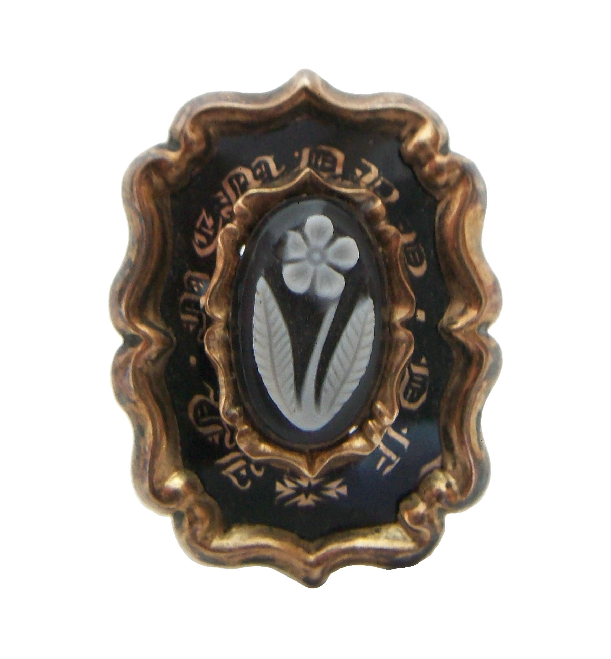 Georgian 15K yellow gold mourning brooch / pin - set with a carved floral agate cameo to the center (approx. 10 mm. x 6 mm.) - the cameo surrounded by an enamel and gold border inscribed with old English script 'IN MEMORY OF' - raised scrolling