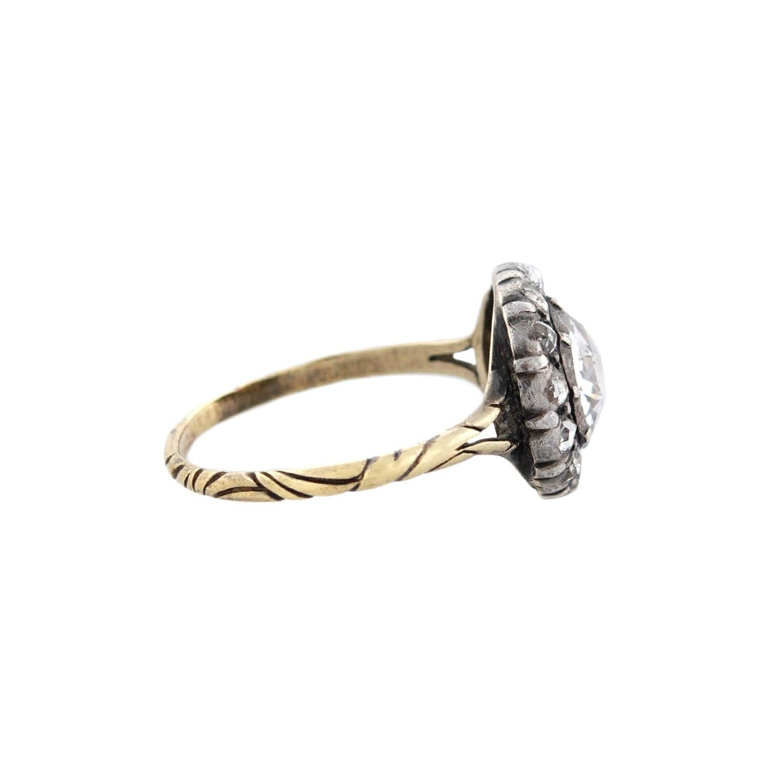 A stunning ring from the Georgian (ca1790s) era! Crafted in 15kt yellow gold and topped in sterling silver, this breathtaking ring adorns a 1.15ctw Rose Cut diamond at its center. The foil-backed stone is held within a lovely collet setting, and it