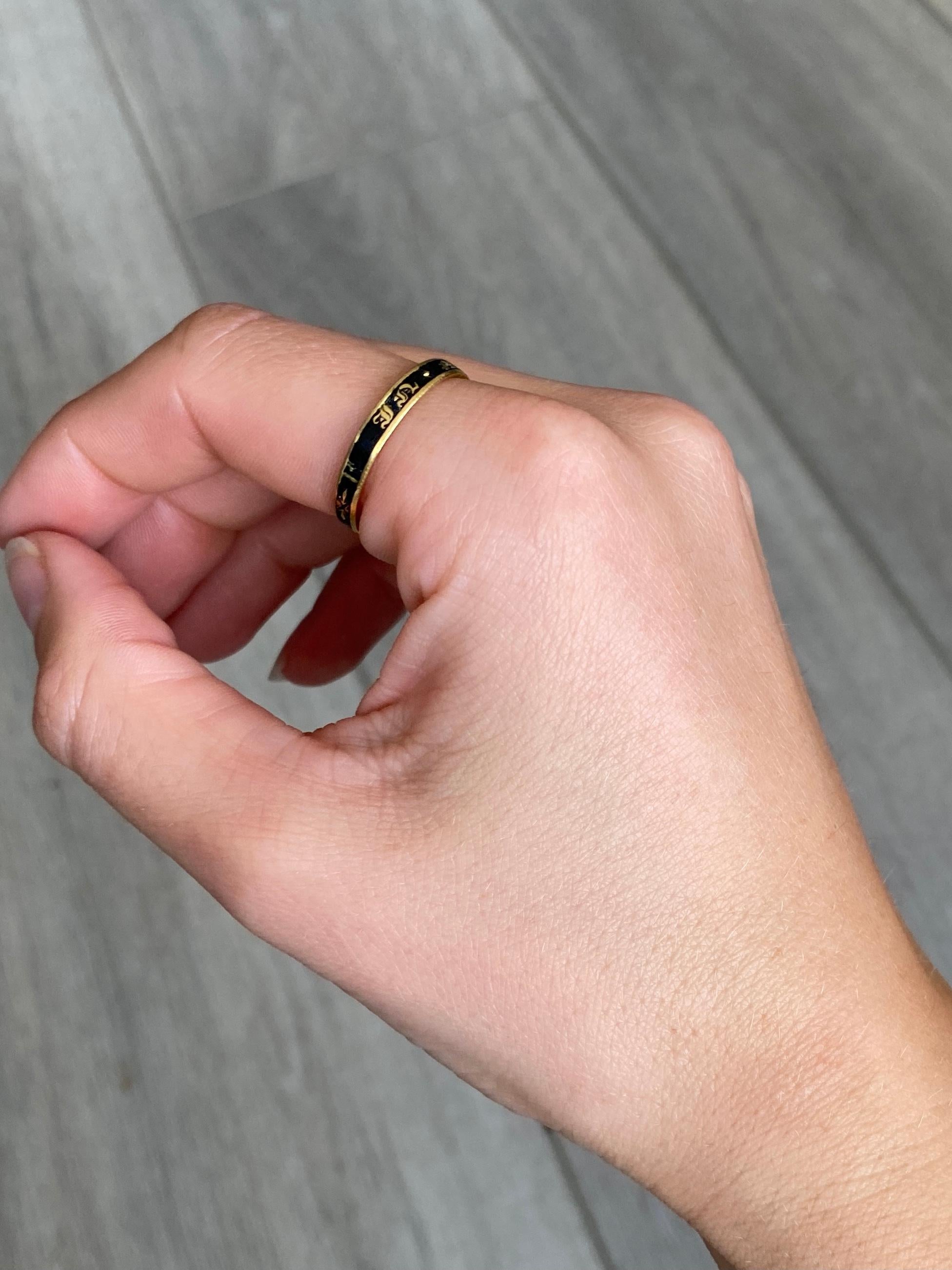 A wonderful antique Georgian mourning band. The band is in-stepped and set with black enamel and gold lettering reading 