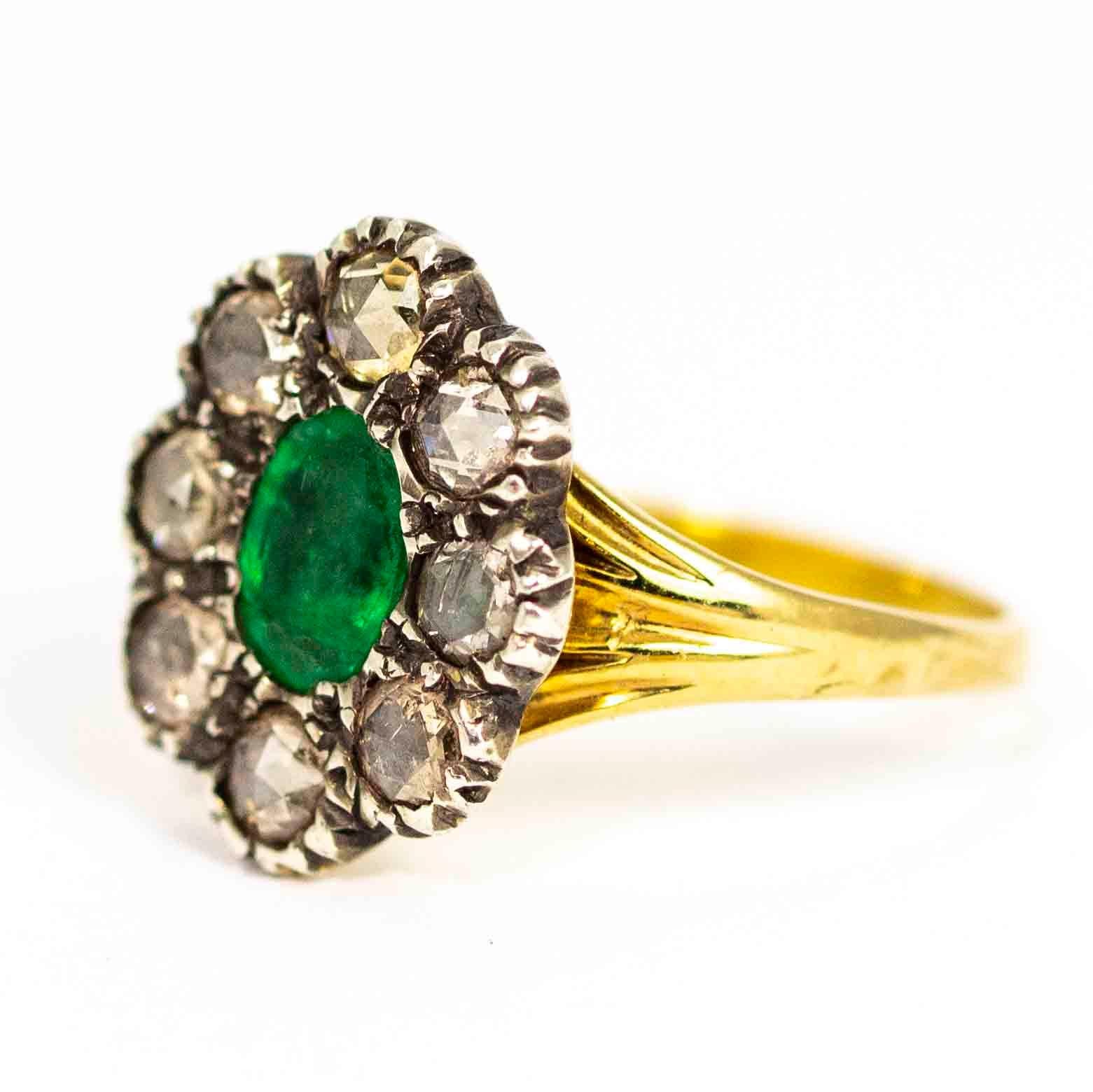 A spectacular antique Georgian cluster ring. The ring is centered with a stunning oval emerald surrounded by a fine halo of eight rose cut diamonds. Each of the diamonds measure approximately 15 points, total carat weight 1.20ct The stones are bezel