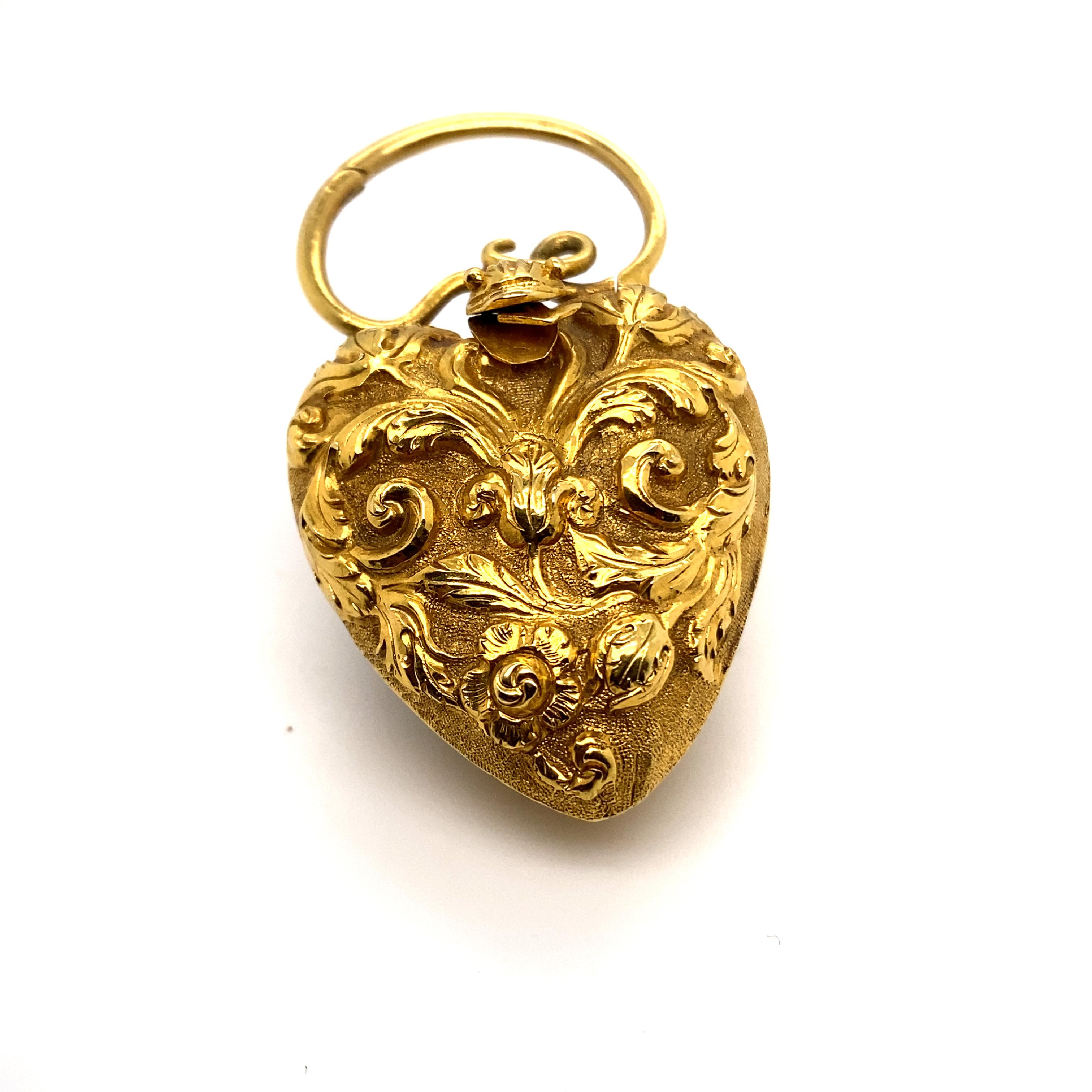 An exceptional Georgian gold heart shaped locket pendant with snake motif and chain, featuring a repoussé foliate design heart locket hinged to memorial glass frame inside, surmounted by an entwined snake and a hinged clasp pendant tail

The glazed