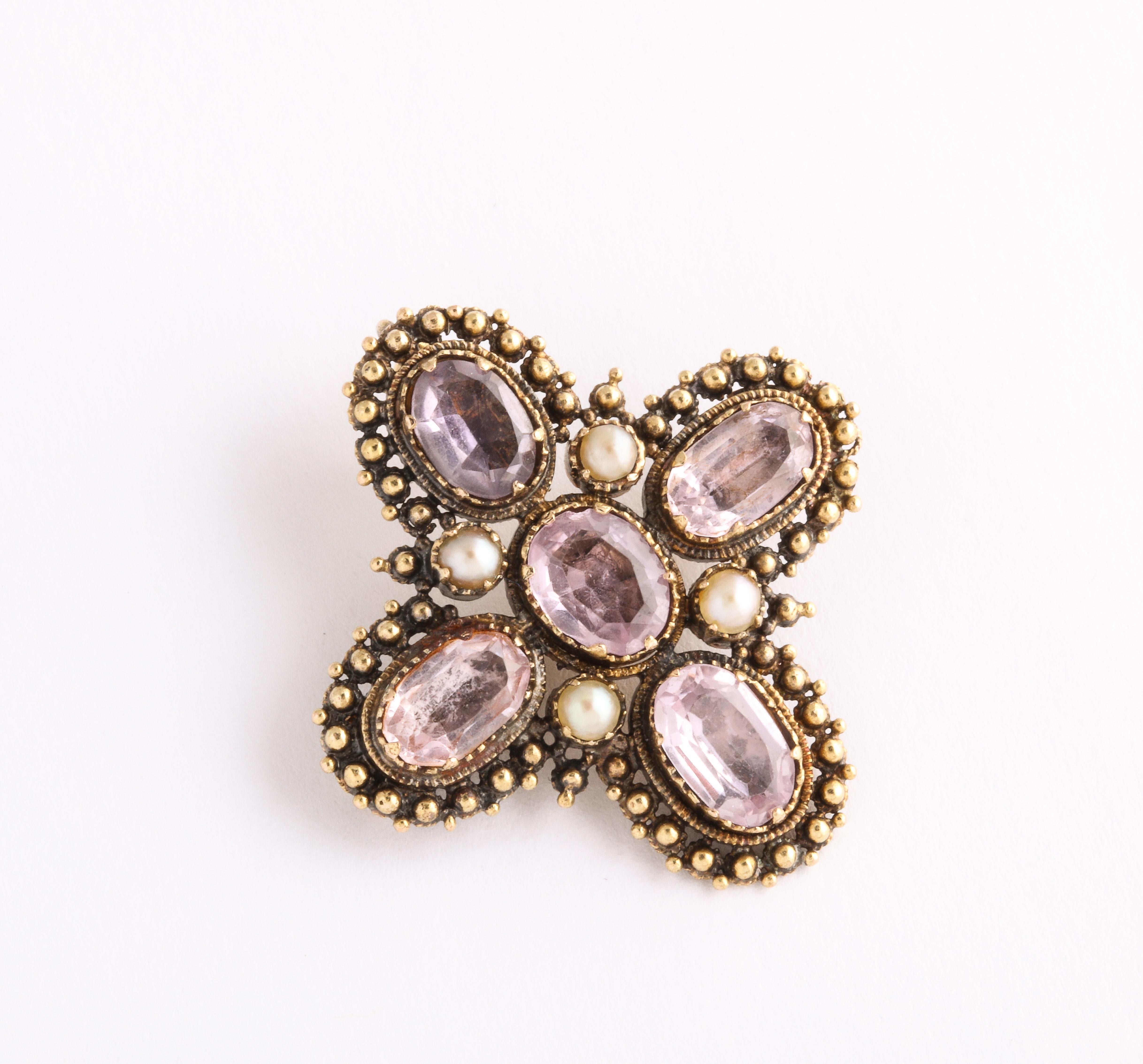 A beautifully granulated pale amethyst and 18 kt gold pendant or brooch that is set with four natural pearls around the center stone. The gems are closed in the back and foiled. The gold does not overpower the amethysts and the granulation gives the