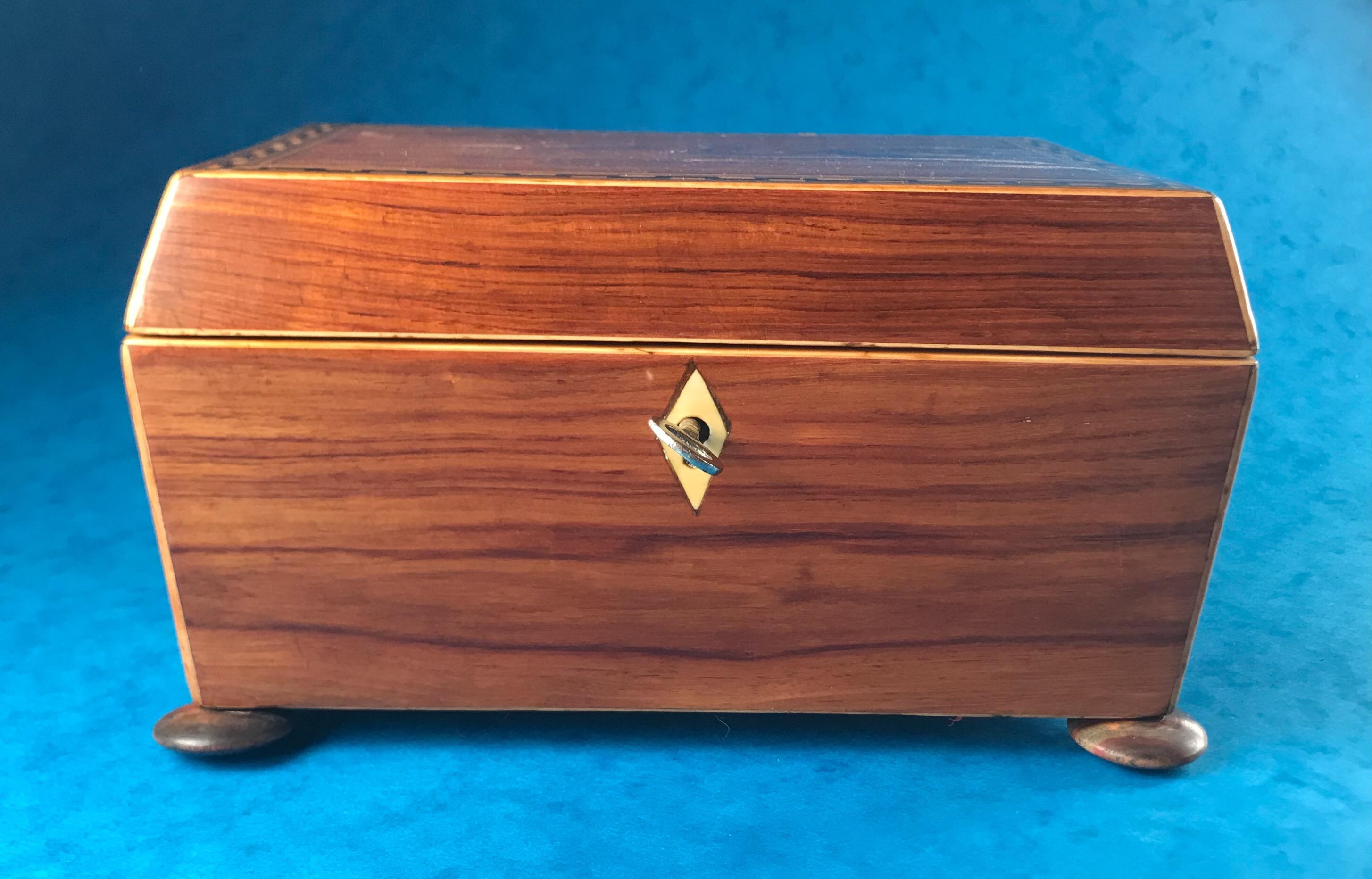 A Georgian 1820 Harewood, ebony and boxwood inlaid Tulipwood box, it sits on four tulip wood bun feet, it has a relined interior and its original tray, unfortunately the key doesn’t work, it measures 19.5 by 14 and stands 11.5 cm high, it’s a
