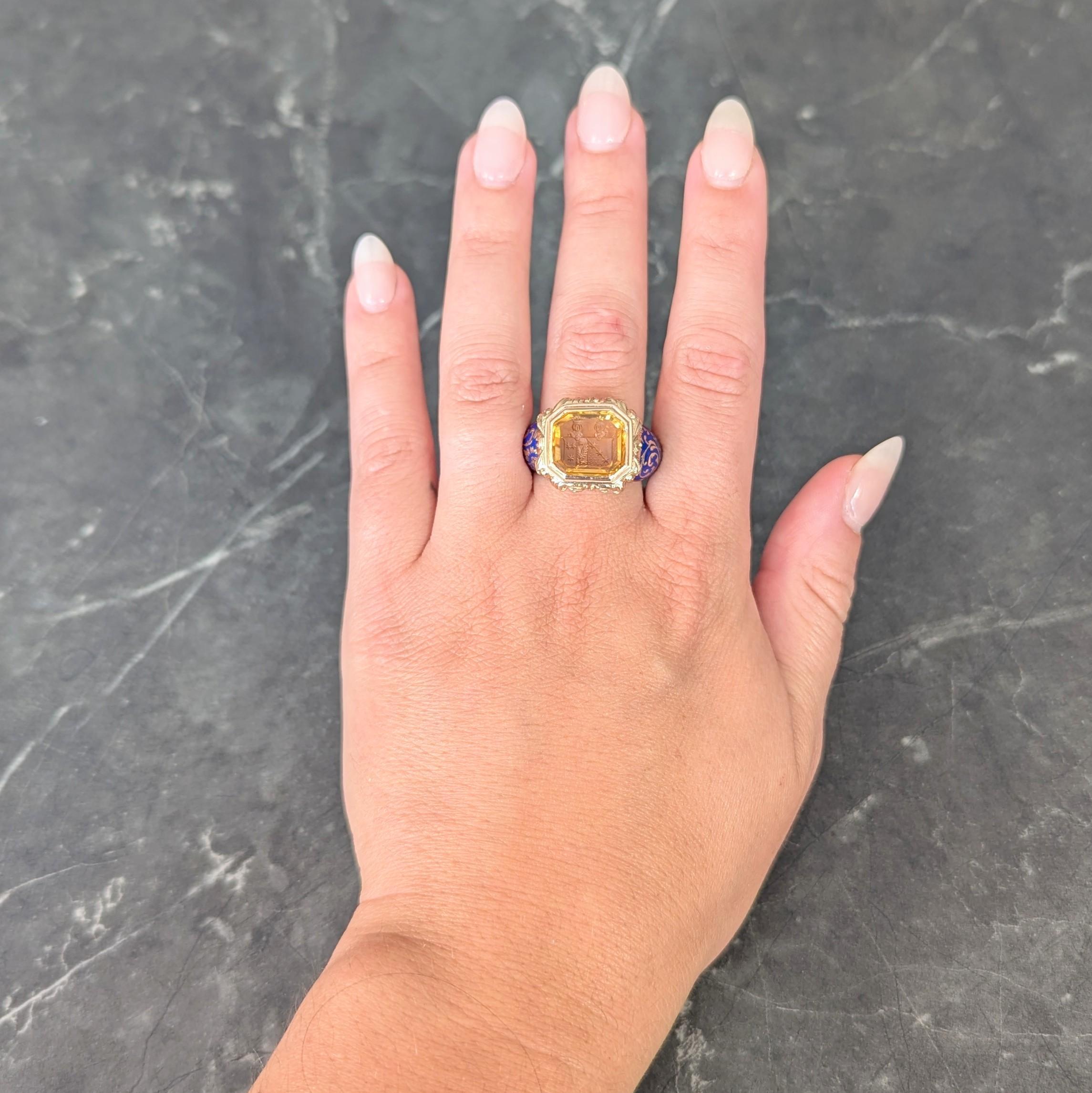 Centering a mixed emerald cut citrine weighing approximately 4.80 carats
Transparent light brownish in color and carved with intaglio
Depicting two heraldic crests with knight helmets, stars, and eagle
Bezel set with dimensionally grooved scrolling
