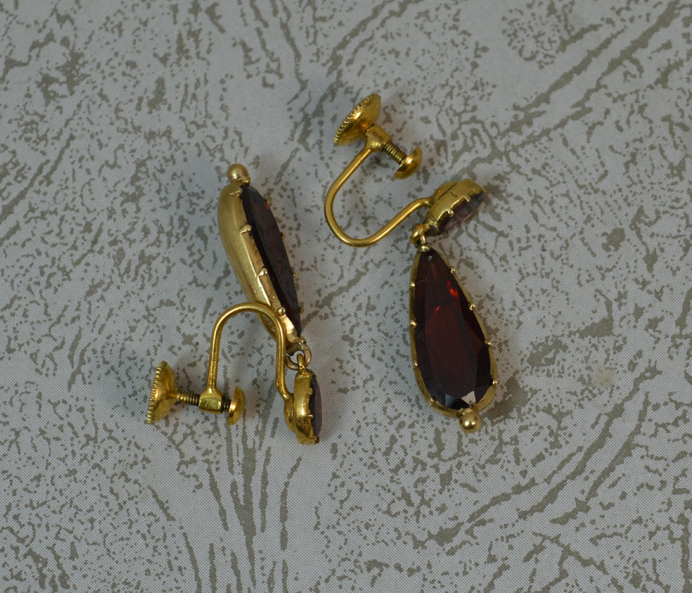 A superb pair of early Georgian period earrings. c1800.
Modelled with 18 carat yellow gold with closed foiled back settings.
Drop dangle torpedo like earrings. Each set with an oval garnet to top and elongated pair garnet below.
26mm total drop