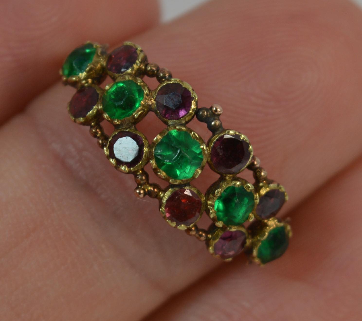 A genuine Georgian period ring.
SIZE ; N UK, 6 3/4 US
Designed with three rows of stones. Five vibrant green paste stones to the centre with a row of round flat cut garnets above and below. All in closed back settings.

19mm x 8mm cluster