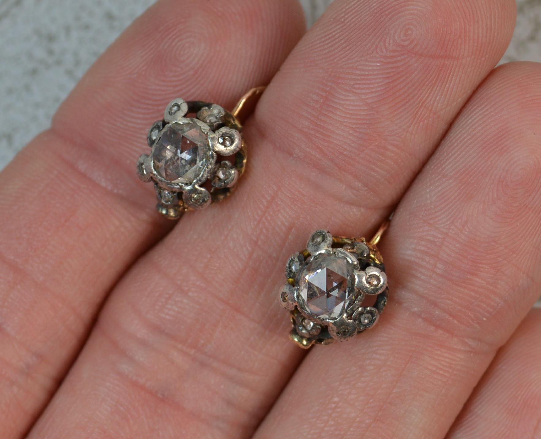 A superb pair of early Georgian period earrings. c1800.
Modelled with 18 carat gold lever backs and silver head collet settings, typical of the era.
5.4mm x 6.2mm centre open back diamonds. Surrounded by tiny little diamonds.

CONDITION ; Good.