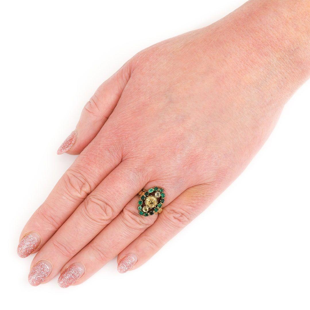 We are thrilled to offer this Georgian 18ct yellow gold, round yellow topaz and emerald marquise shape cluster ring. Made with embellished floral motifs to the shoulders, the stones are foiled back by the gold setting which was typical technique