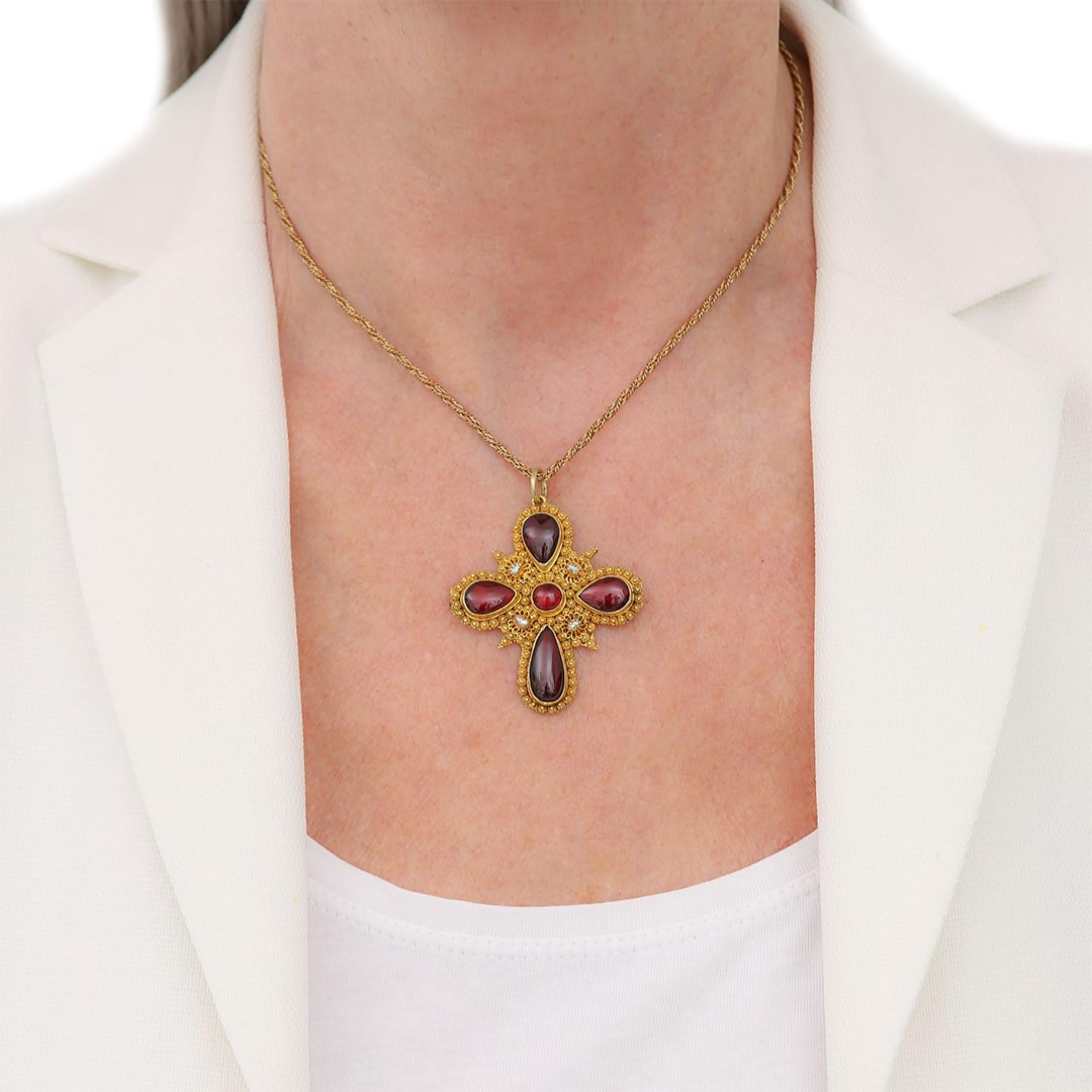 A fine and impressive Georgian 18ct yellow gold garnet cabochon or carbuncle and natural pearl cross dating from circa 1820. The beautifully crafted cannetille work making up the majority of the body of the cross with the deep, pigeon blood red