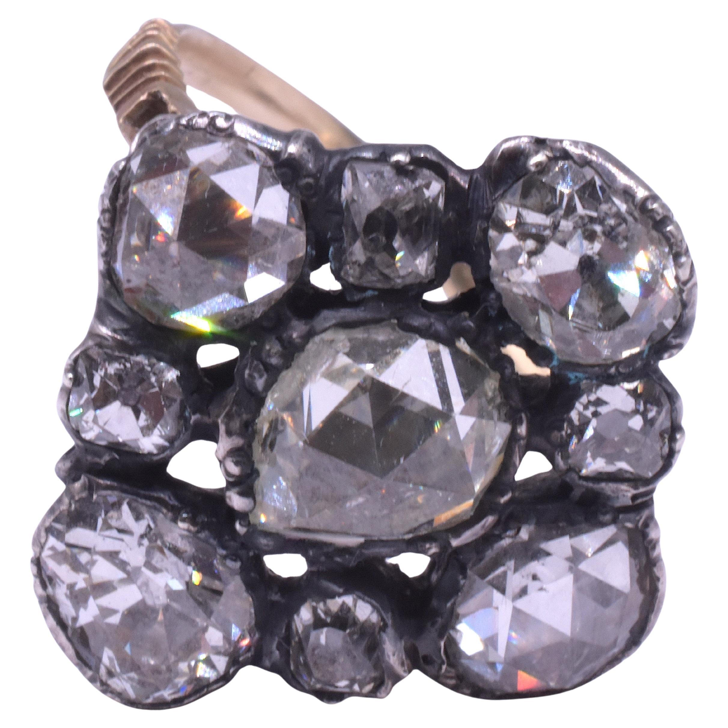 Un raro anello a grappolo di diamanti risalente al 1810, in un insolito formato triangolare. Al centro c'è un grande diamante taglio rosa incastonato. Agli angoli ci sono 4 grandi diamanti taglio rosa affiancati da 4 diamanti più piccoli. Tutti i