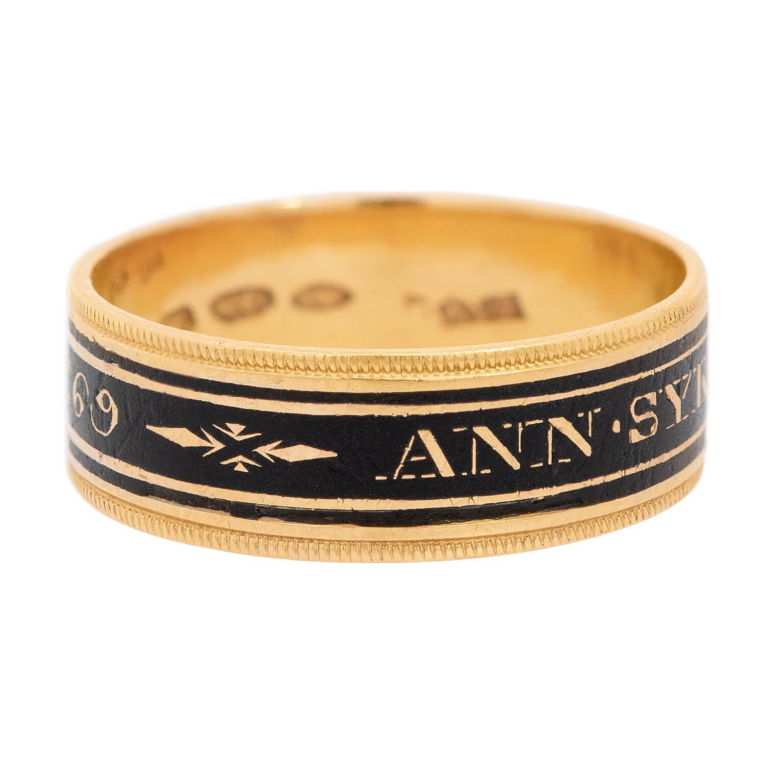 An exquisite wedding band from the Georgian (ca1810) era! This gorgeous ring is crafted in 18k yellow gold, and features a thick stripe of black enamel. The enamel is adorned with a personalized engraving which reads: 