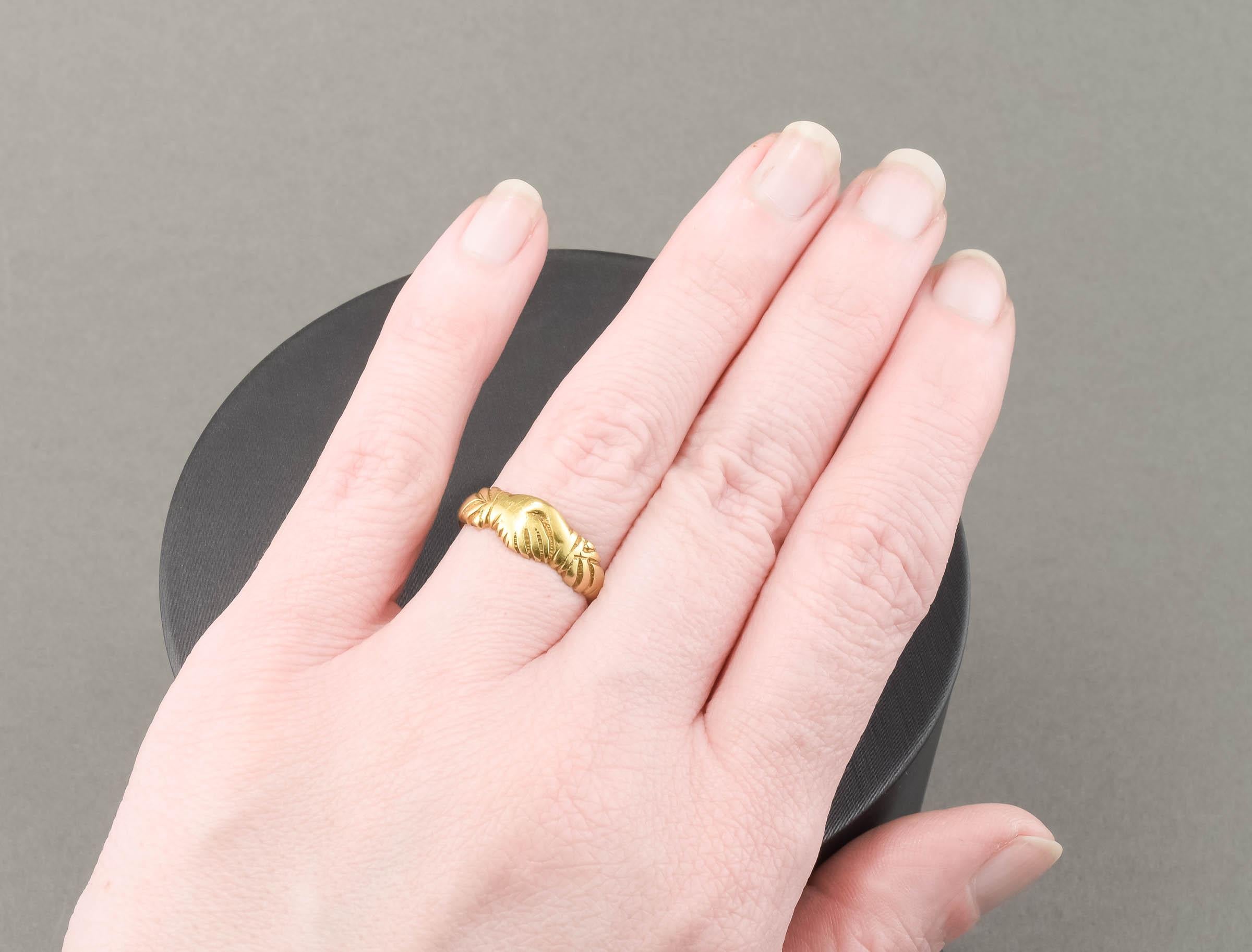Fabriquée en or pur 18 carats, la bague représente le symbole éternel de l'amour, de l'amitié et du partenariat - deux mains jointes. (Les anneaux de Fede remontent aux IIIe et IVe siècles et sont devenus particulièrement populaires au Moyen Âge.