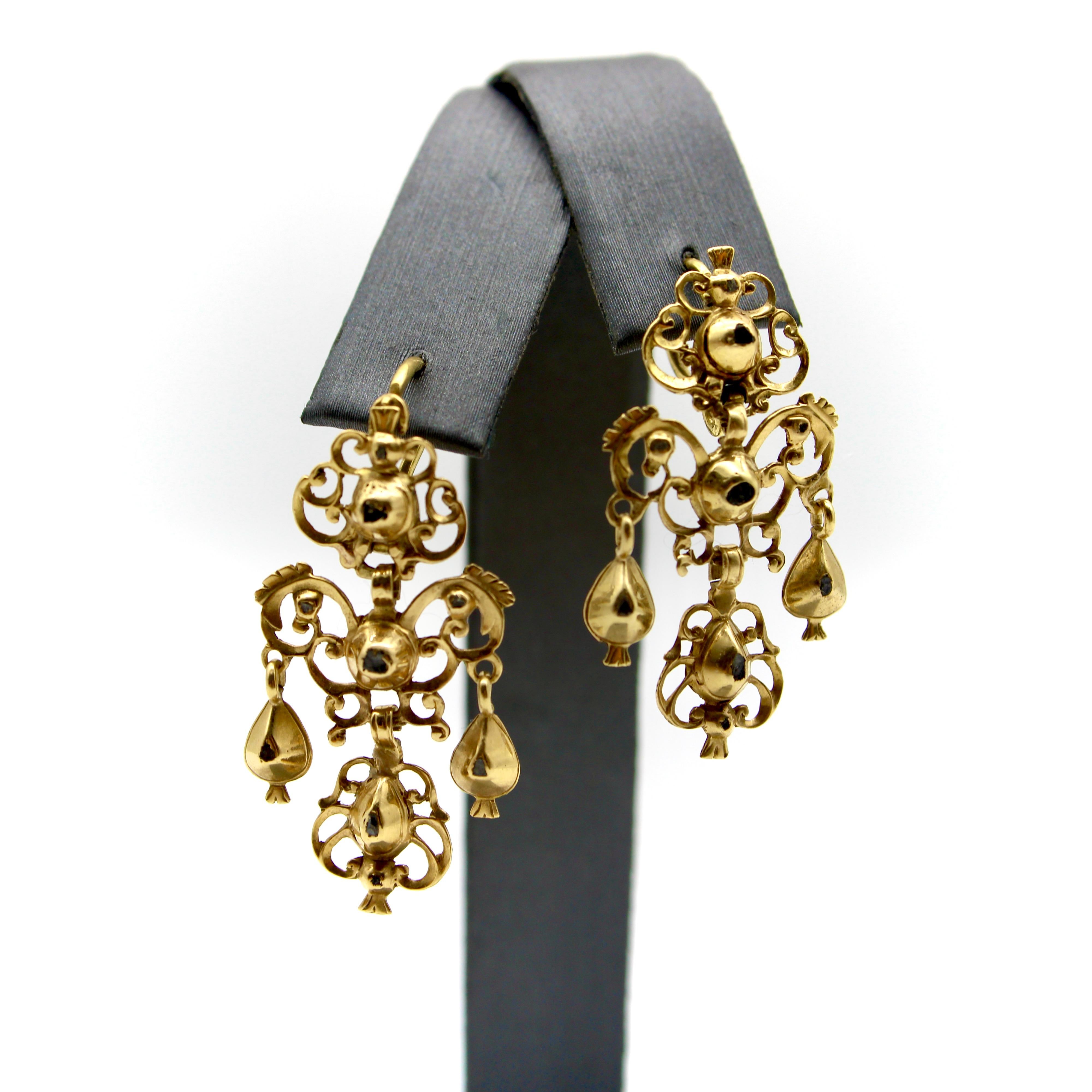 Emblematic of Portuguese jewelry, these Georgian sequilé earrings are completely handmade from 18k gold, circa 1780-1820. Beautiful table and rose cut diamonds are encapsulated in gold, their tips peaking out of windows in the gold in a way that