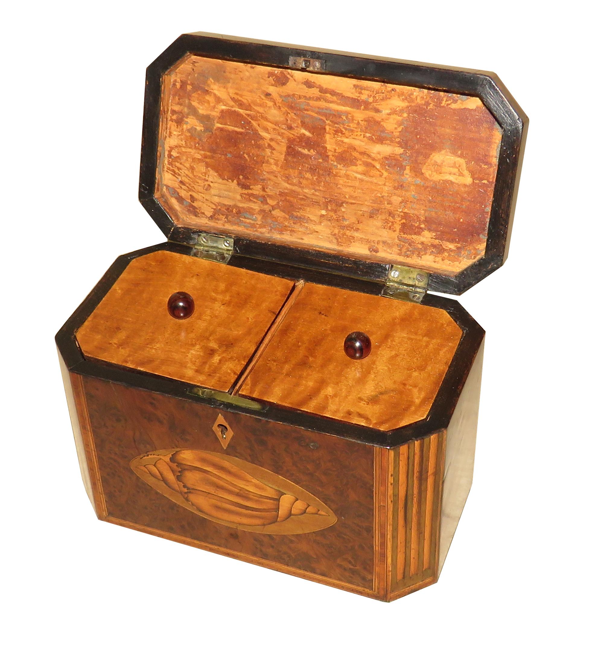 A delightful George III period, late 18th century
Burr yew wood octagonal shaped tea caddy
Having charming inlaid decoration, including
Conch shells, and hinged lid enclosing lidded
Divisions with fully working lock and key

(This is a very