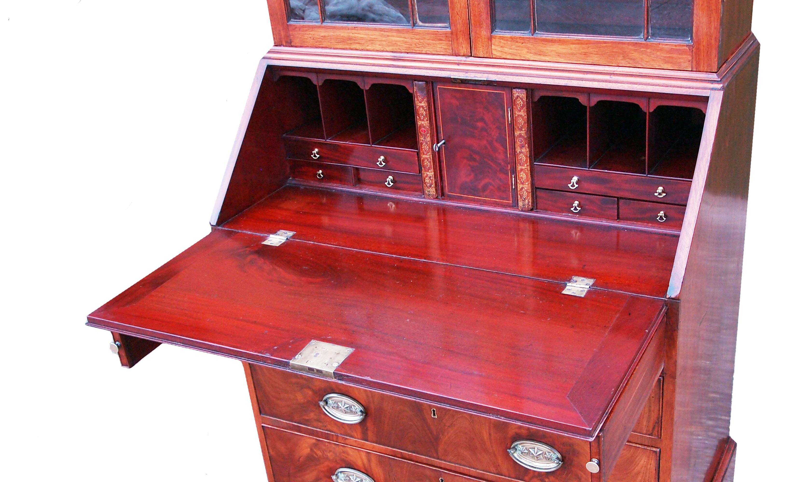 A very attractive and good quality George III period mahogany bureau
bookcase having unusual castellated and carved cornice above pair of 13
pane astragal glazed doors, superbly figured flap and four long drawers
with replacement brass oval plate