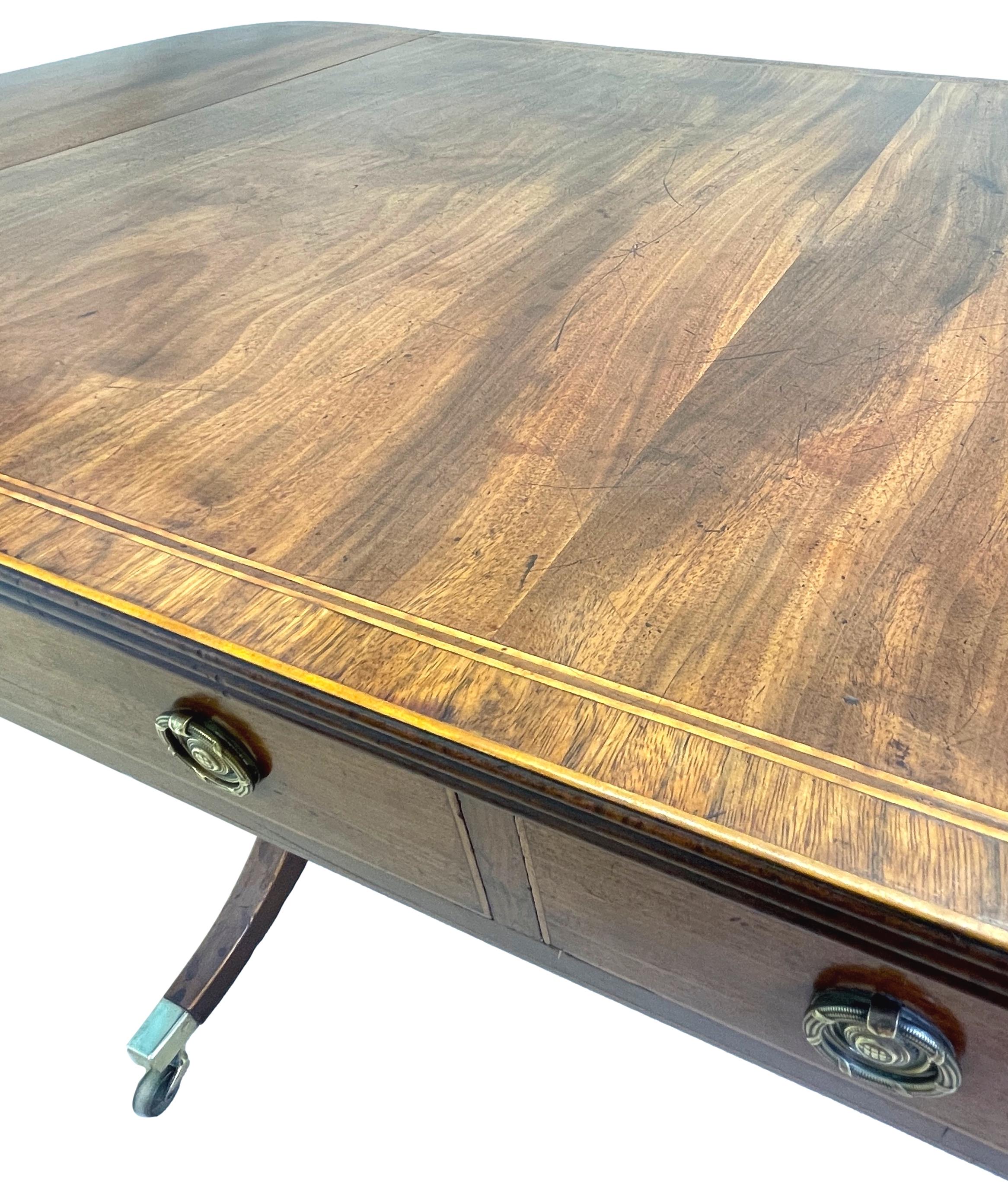 A Very good quality late 18th century Georgian mahogany sofa table, having superbly figured two flap top bearing crossbanded decoration, over two drawers to frieze opposed by dummy drawers to reverse, raised on elegant square tablet end supports