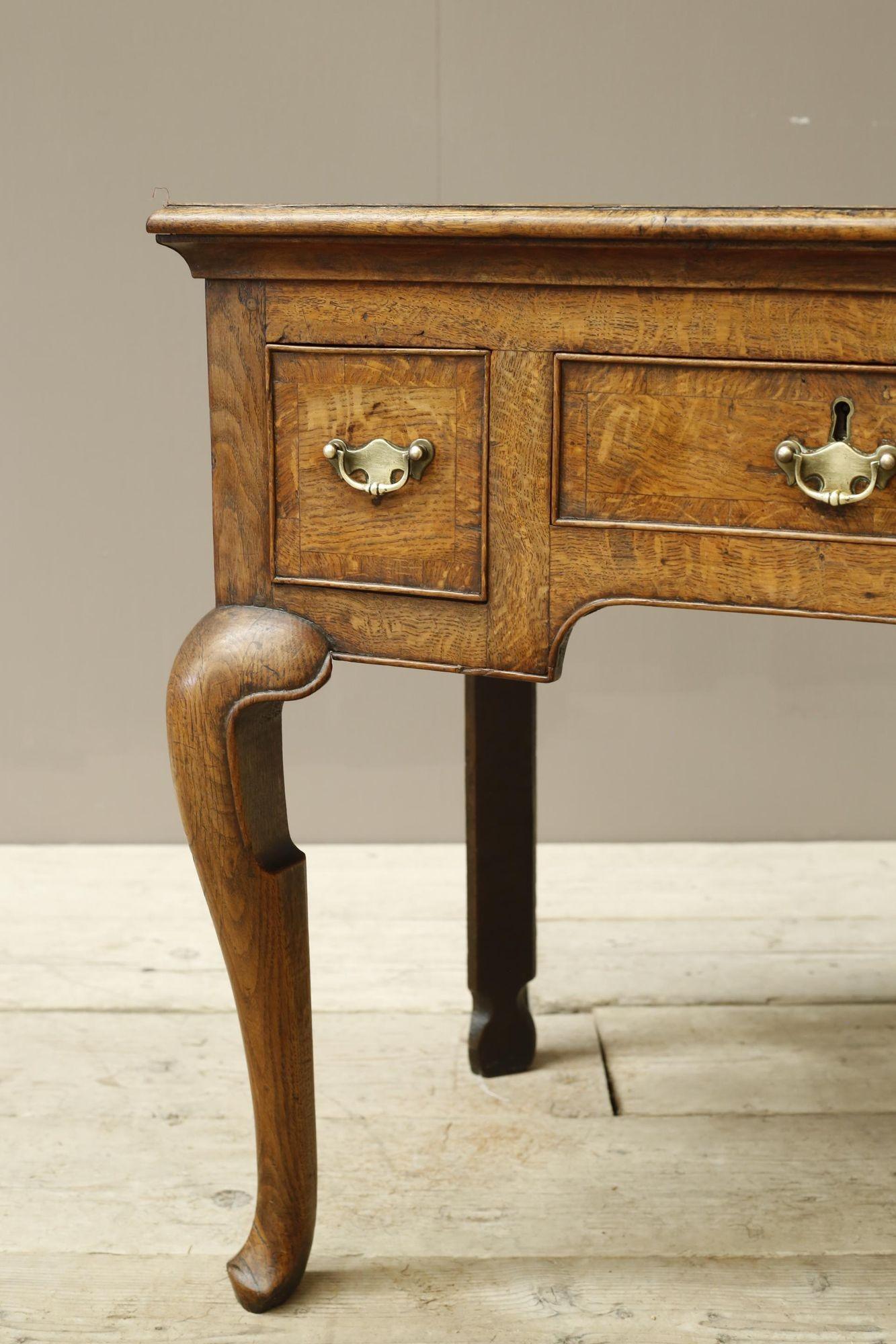 This is a very high quality 18th century oak lowboy. It is a wonderful design that sets apart from the rest. Thick shield topped cabriole front legs and shaped back legs with the most incredible figured top which simply isn't done justice in the