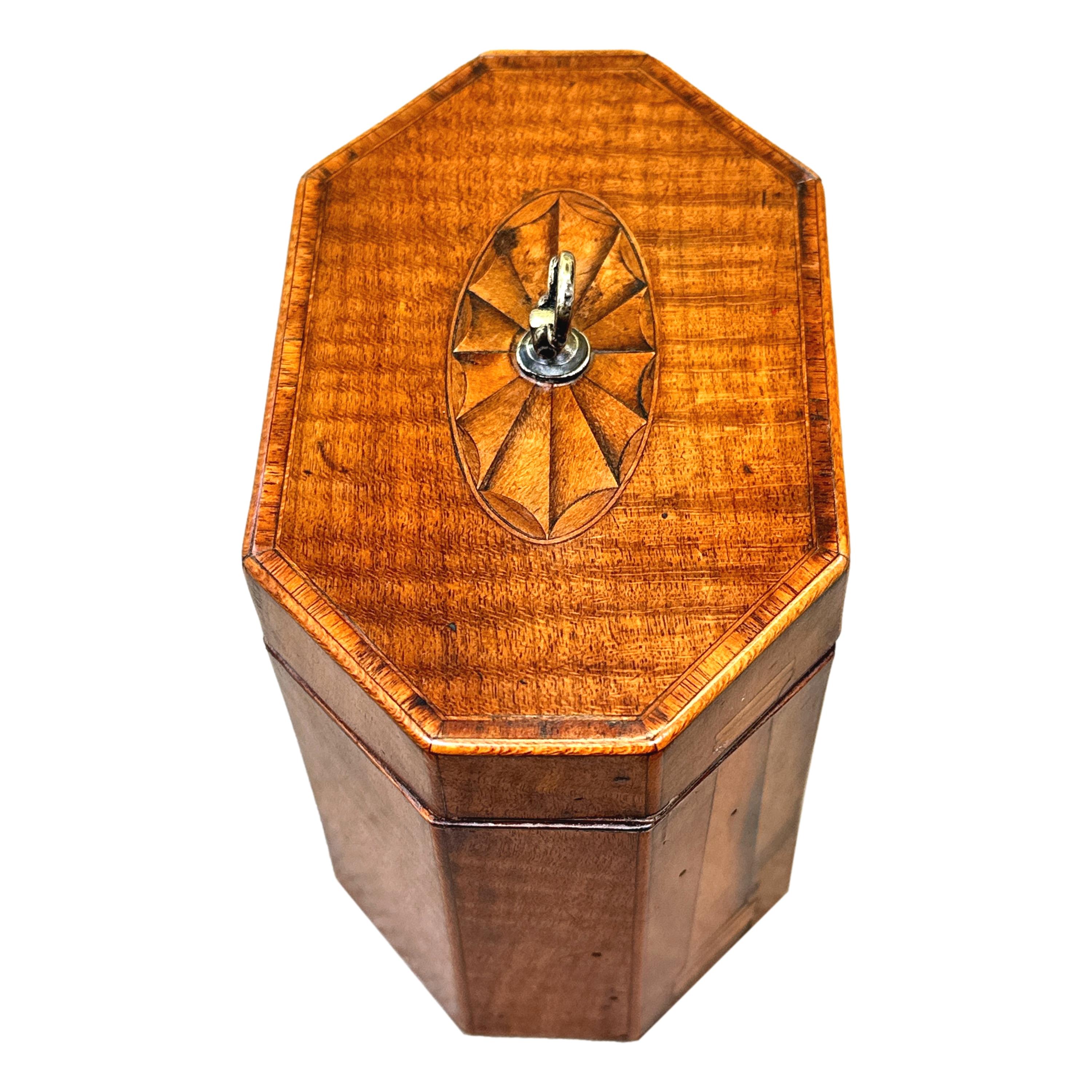 An Very Unusual Late 18th Century George III Period Mahogany Octagonal Tea Caddy, Having Rare Attractive Inlaid Decoration Of Fans And Pillars, With Hinged Lid Enclosing Lidded Compartment.

Tea was an extremely precious commodity throughout the