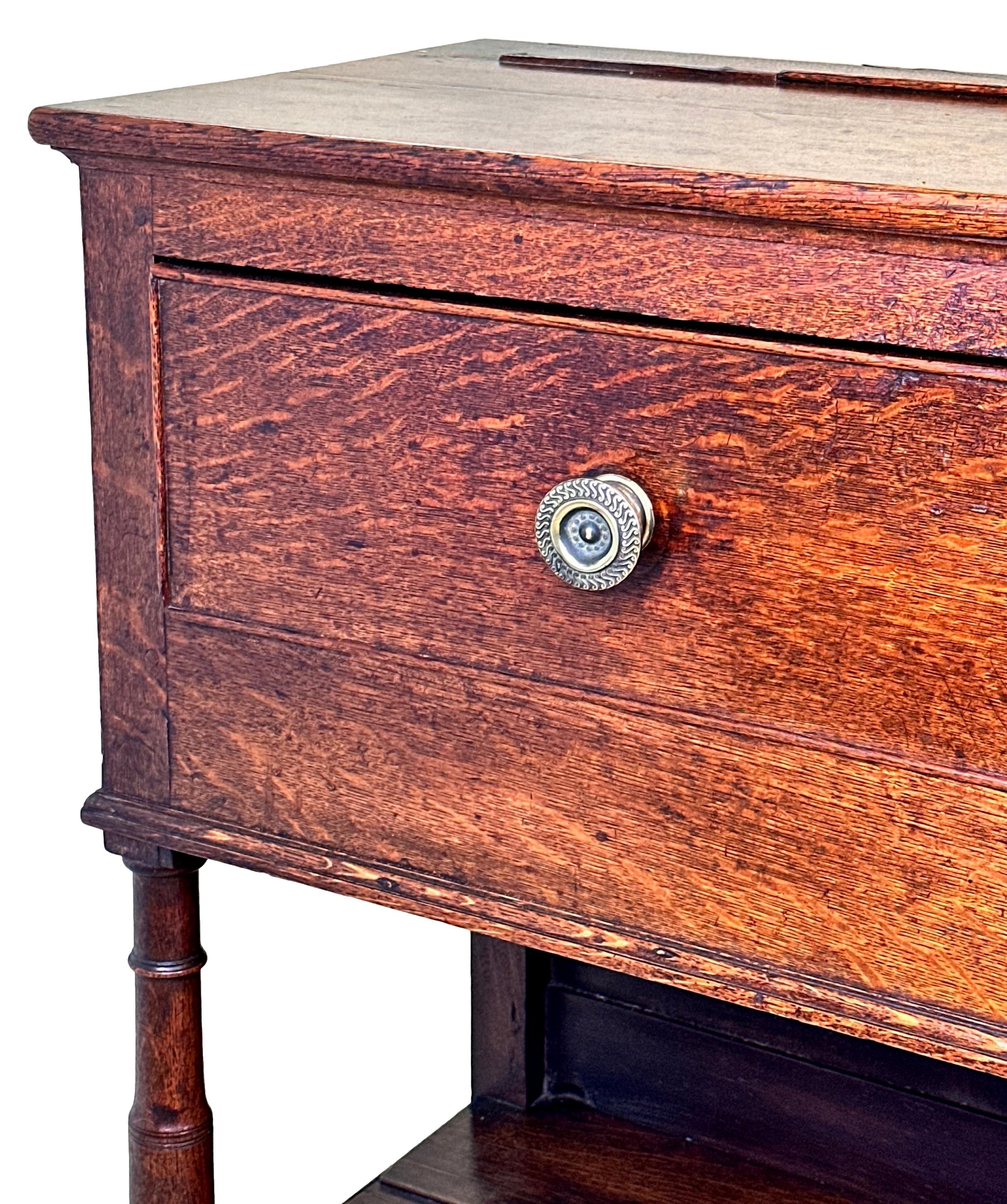 An Attractive And Very Good Quality Late 18th Century, George III Period, Oak Dresser Base Of Good Colour And Patina Throughout, Having Three Frieze Drawers With Replacement Knobs, Over Elegant Turned Upright Supports With Original Potboard Shelf