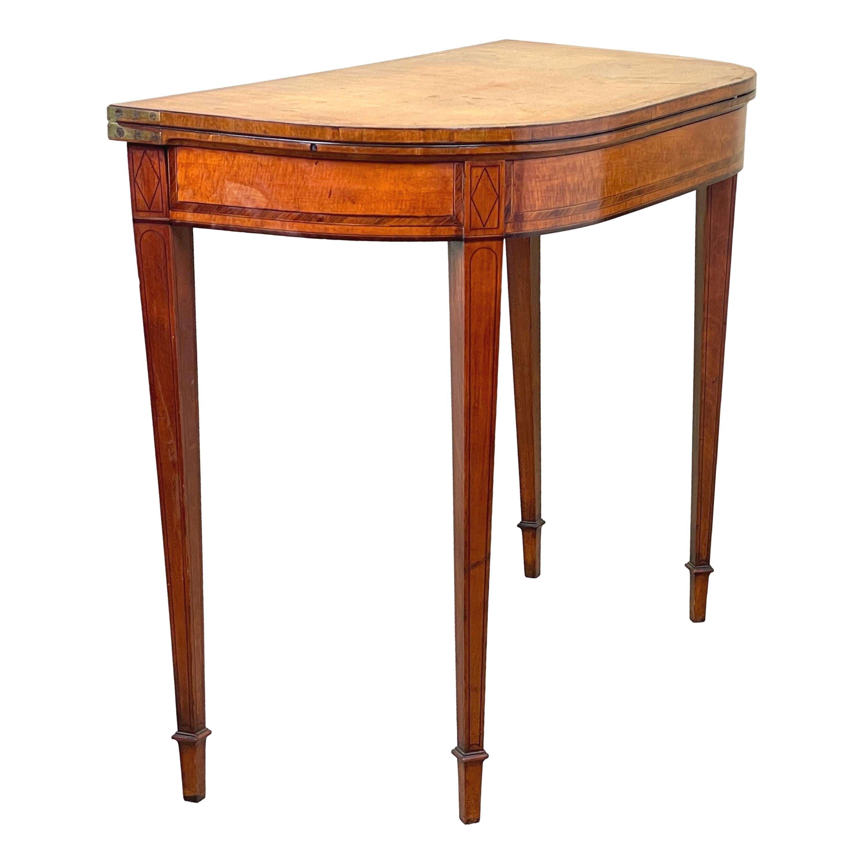 A Very Good Quality, English 18th Century Georgian Sheraton Period, Satinwood Card Table Of D Shaped Form, With Attractive Crossbanded And Ebonised Inlaid Decoration To Well Figured Foldover Top, Over Frieze Raised On Extremely Elegant Square