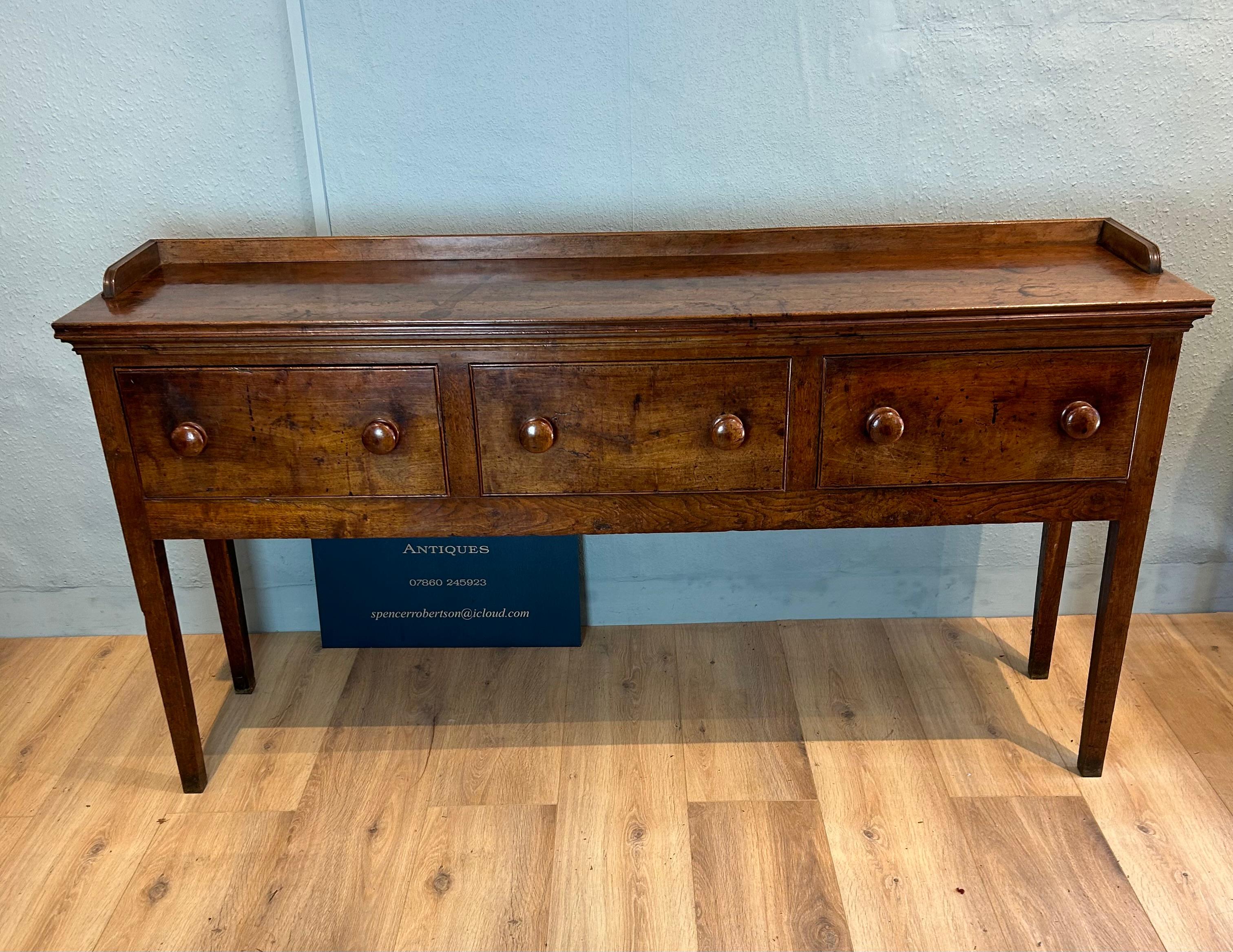 Dresser base in walnut & oak circa 1790, solid walnut moulded top and gallery, three honey coloured walnut drawer fronts with original turned knobs on square tapered legs the dresser base retaining its original untouched patina with age related
