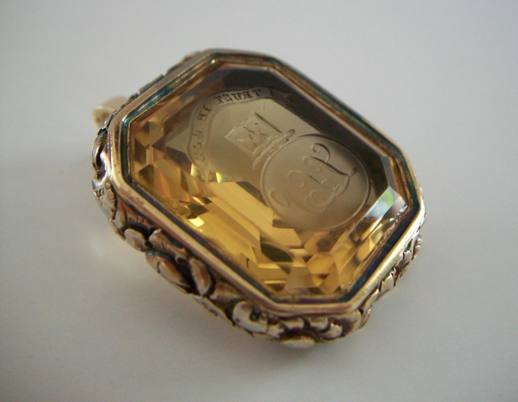 Exceptional Georgian carved Citrine Fob / Pendant / Enhancer - featuring a large Emerald cut yellow Citrine (approx. 56.19 Total Carat Weight - 23 mm. Wide x 28 mm. Long x 13 mm. Deep) - the Citrine carved in reverse with the motto 'I Trust in God'