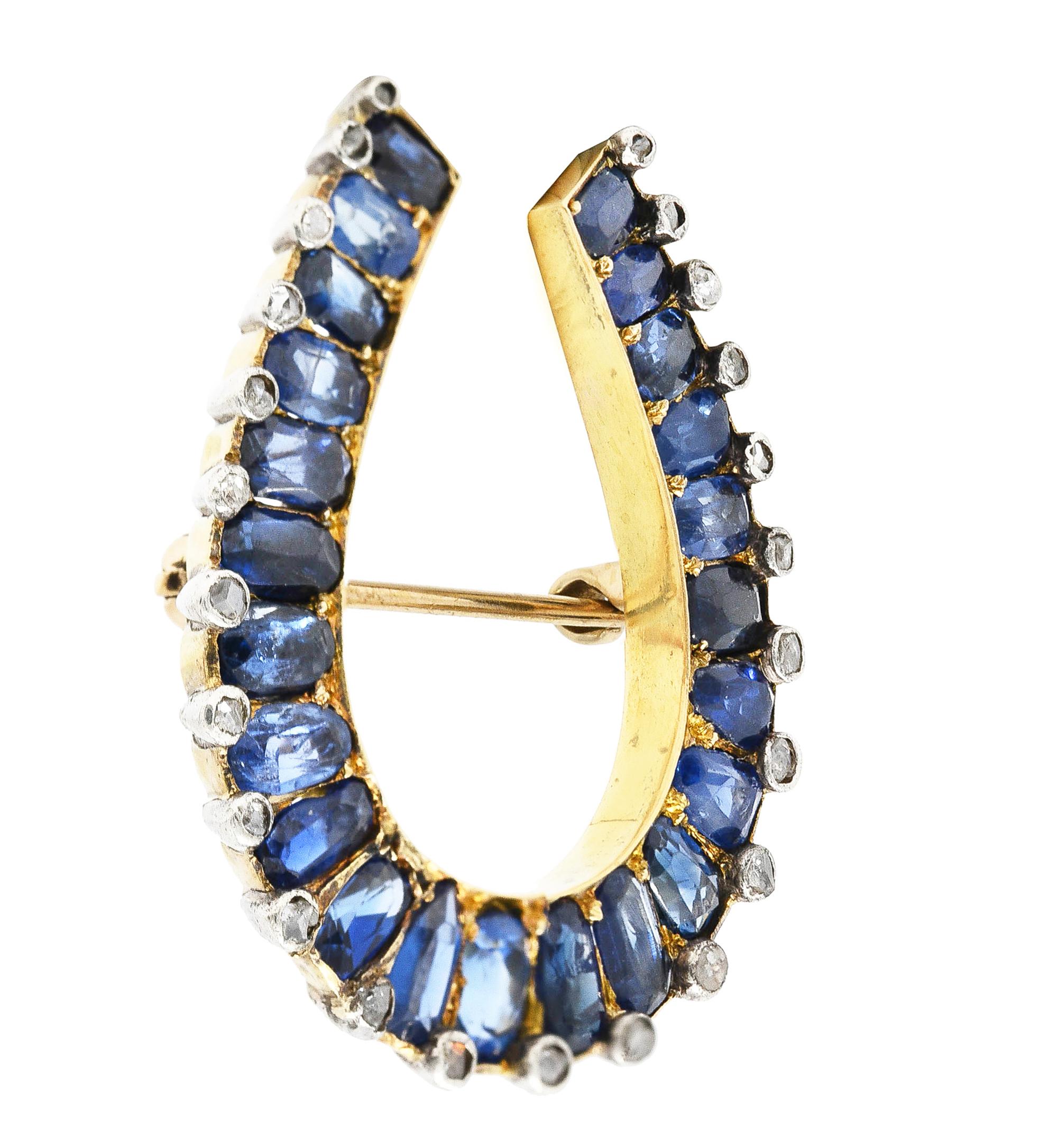 Designed as a horseshoe form with mixed oval cut sapphires bead set around. Weighing approximately 6.38 carats - transparent light to medium blue in color. Accented by rose cut diamonds set in silver bezels and weighing approximately 0.36 carat
