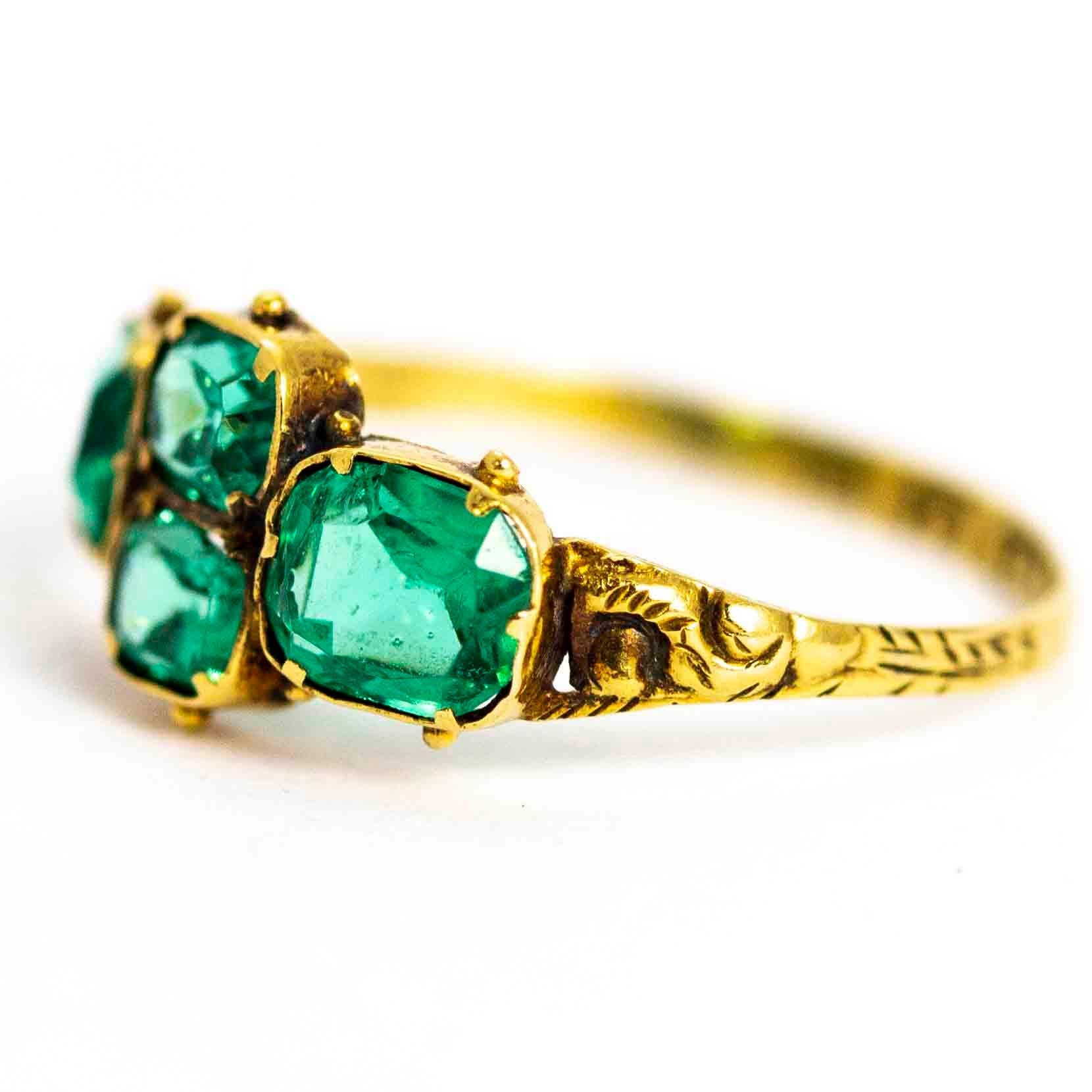 A superb antique ring from the George III period. The ring is set with four beautiful pale green pastes, and decorated with ornate hand-chased detailing across the shoulders and band. Modelled in 9 carat yellow gold. Fully hallmarked 1789
