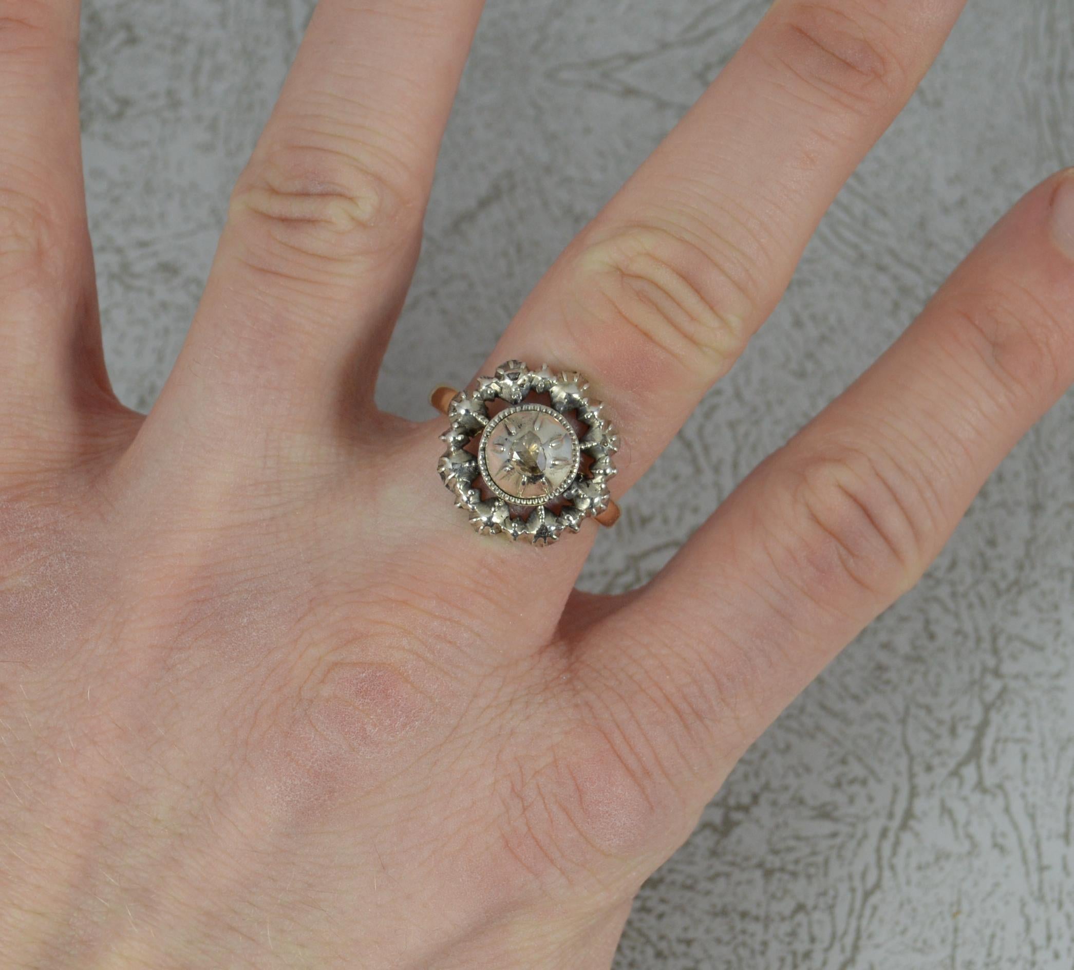 A very fine Georgian period ring. c1760-90.
Designed with a circular panel head in silver. 17.5mm diameter. Set with a rose cut diamond to centre with four smaller diamond chips to the border.
Complete on a 9k yellow gold shank.
Rare