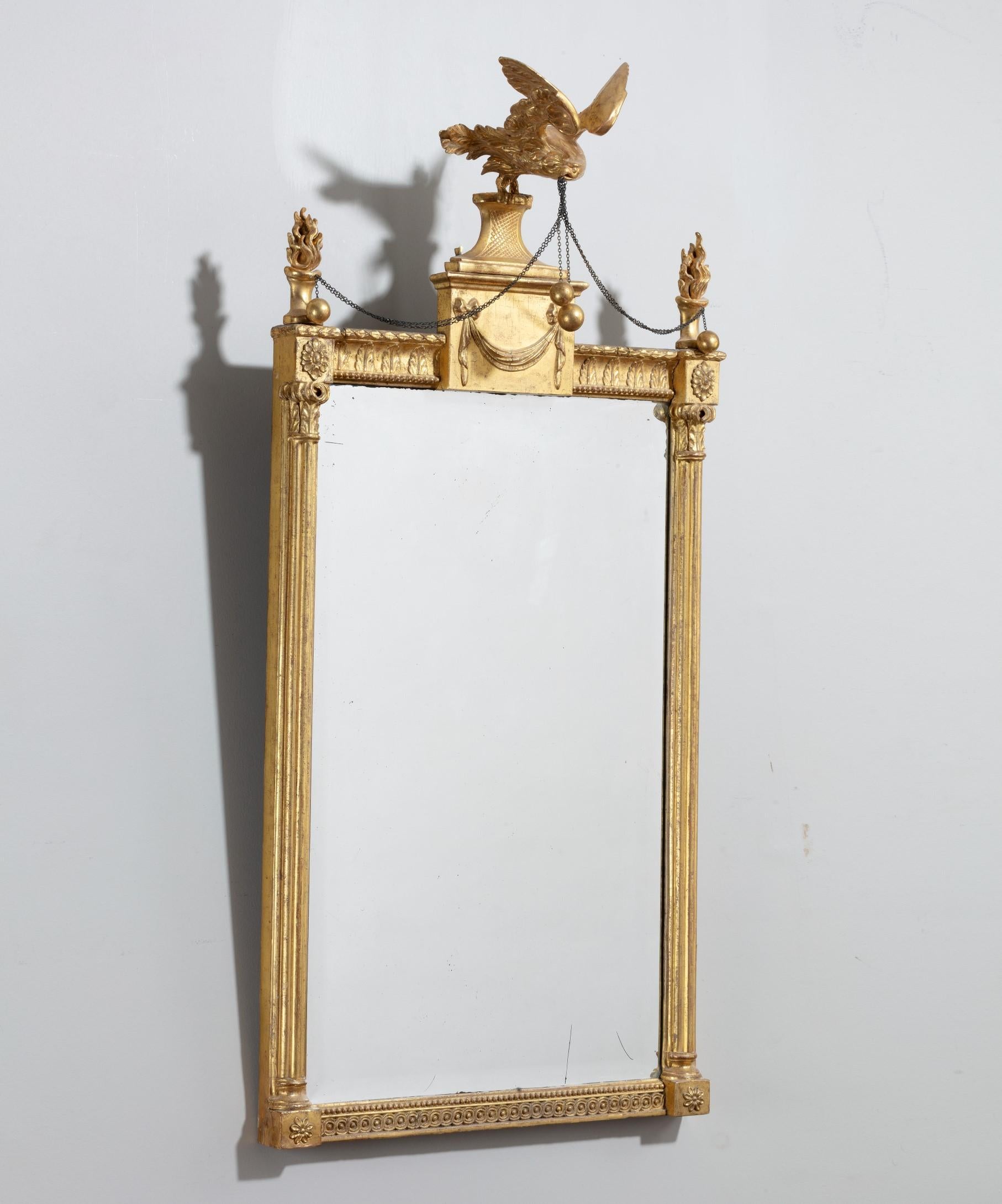 An elegant George III period Adam period giltwood pier glass mirror; the original bevelled mirror plate set within a giltwood neoclassical frame; the mirror's giltwood frame has acanthus leaf cornice with a central entablature topped by a carved