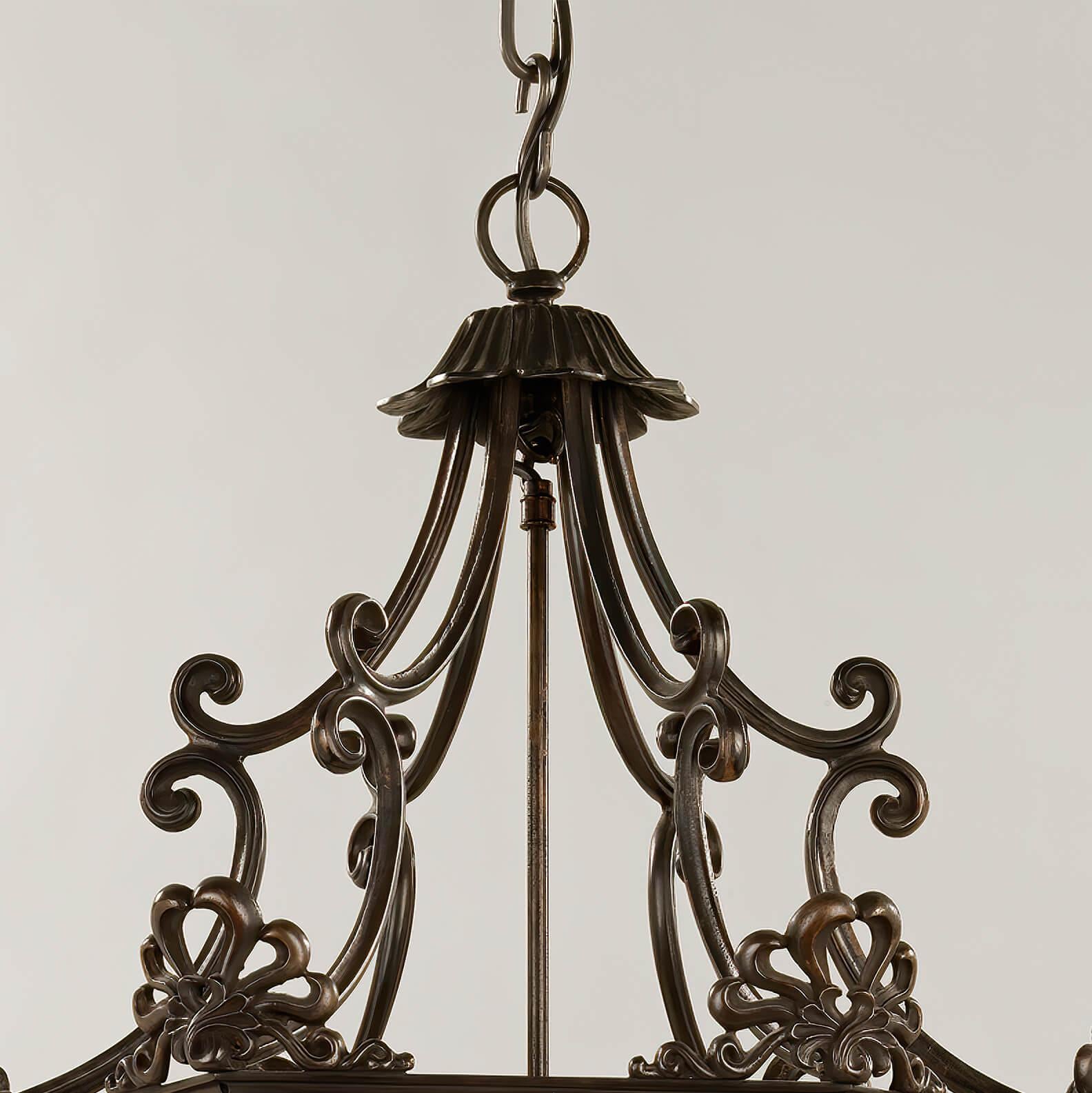 The ornate Georgian bronzed hexagonal hall lantern with pagoda form scroll metal crown, with Anthemion forged mounts, six glass panels with door, a Fleur-de-lis mounted column frame with five-lights and melon ball base finials.

Dimensions: 21.5