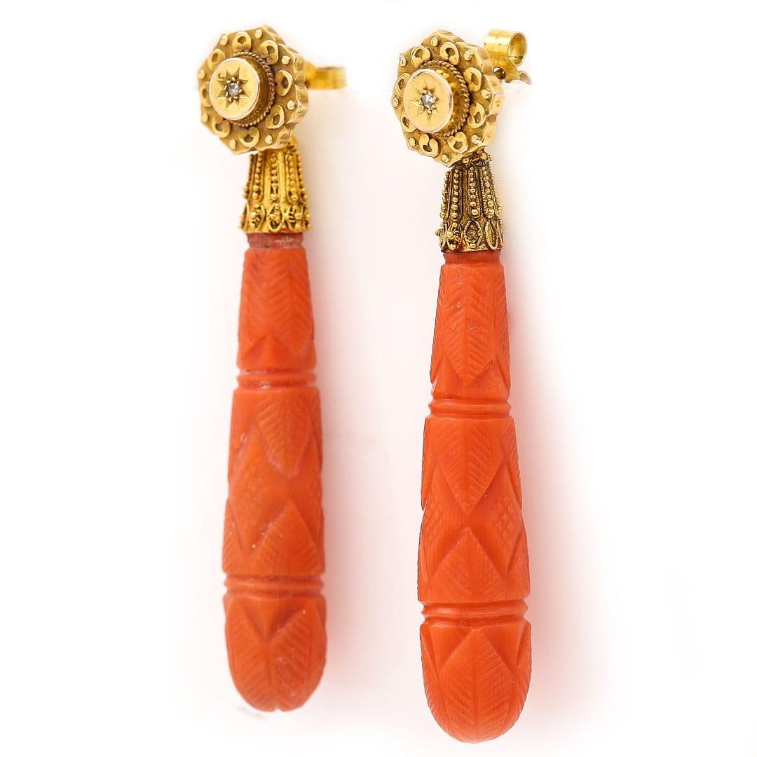 A stunning and rare pair of early 19th century torpedo, carved pink coral drop earrings set in 15ct yellow gold with detachable diamond set heads. The gold fittings are intricately decorated in the typical fine granulation and cannetille work common