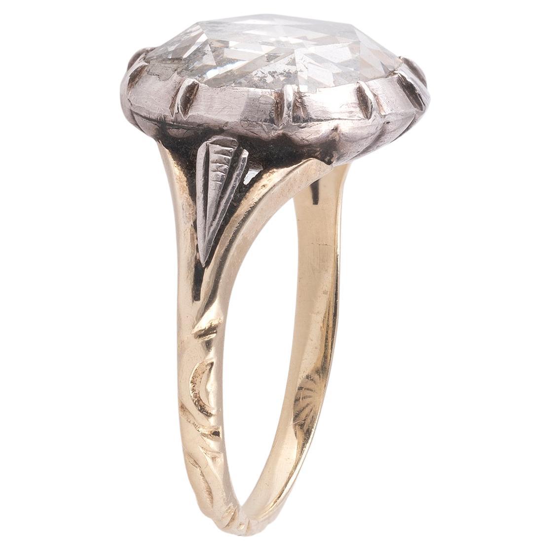 Der runde Diamant im Rosenschliff in geschlossener Silber- und Goldfassung und graviertem Goldschaft.
Rosenschliff (D. 10,5 mm). Gewicht 3,3g.
Größe: 6 1/2
