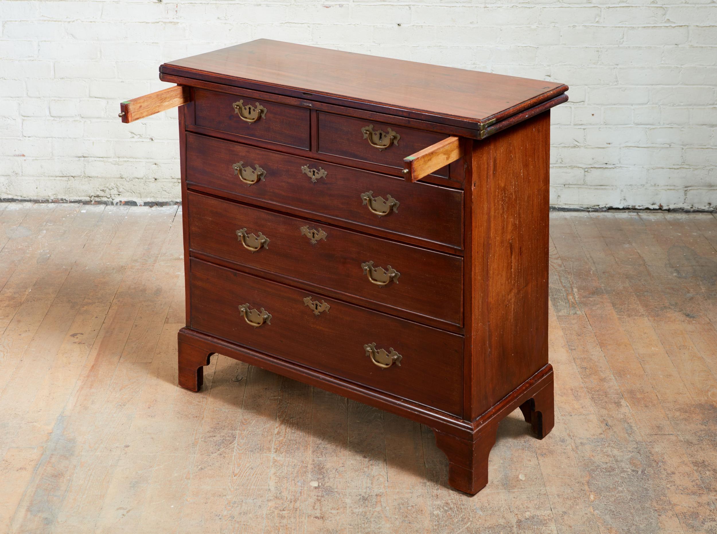 Fine George III mahogany bachelor's chest, the richly grained fold over top with molded edge, over two short and three long drawers, and standing on original bracket feet, the whole with nice old surface and patination.
