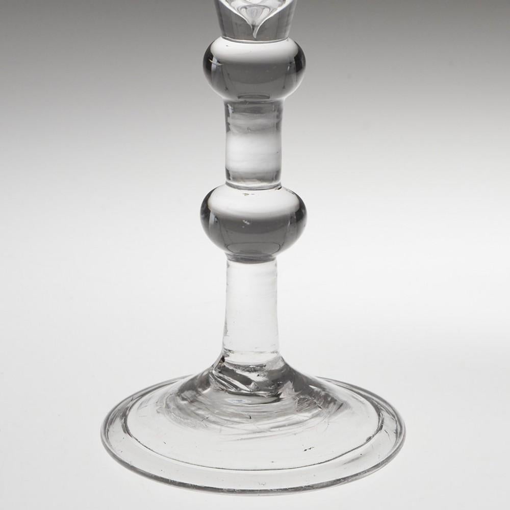  Heading : Balustroid stem Georgian wine glass
Period : George II - c1745
Origin : England
Colour : Clear
Bowl :  Conical
Stem : Flattened ball collar and medial ball knop.
Foot : Folded conical
Pontil : Snapped
Glass Type : Lead
Size :  18cm
