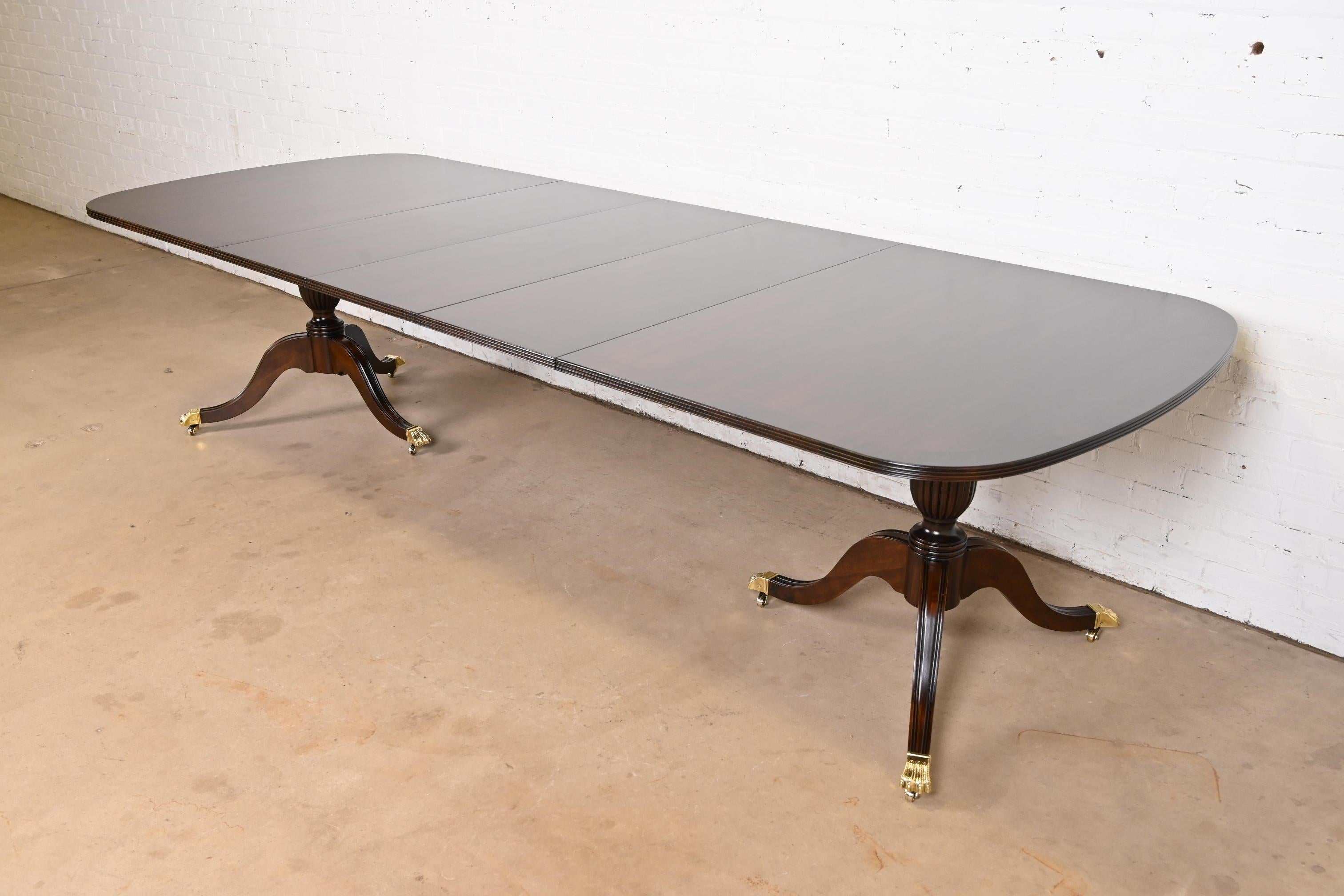An exceptional Georgian, Chippendale, or Regency style double pedestal extension dining table

By Lexington Furniture

USA, Late 20th Century

Beautiful book-matched banded mahogany top, with carved solid mahogany pedestals, and brass paw feet on