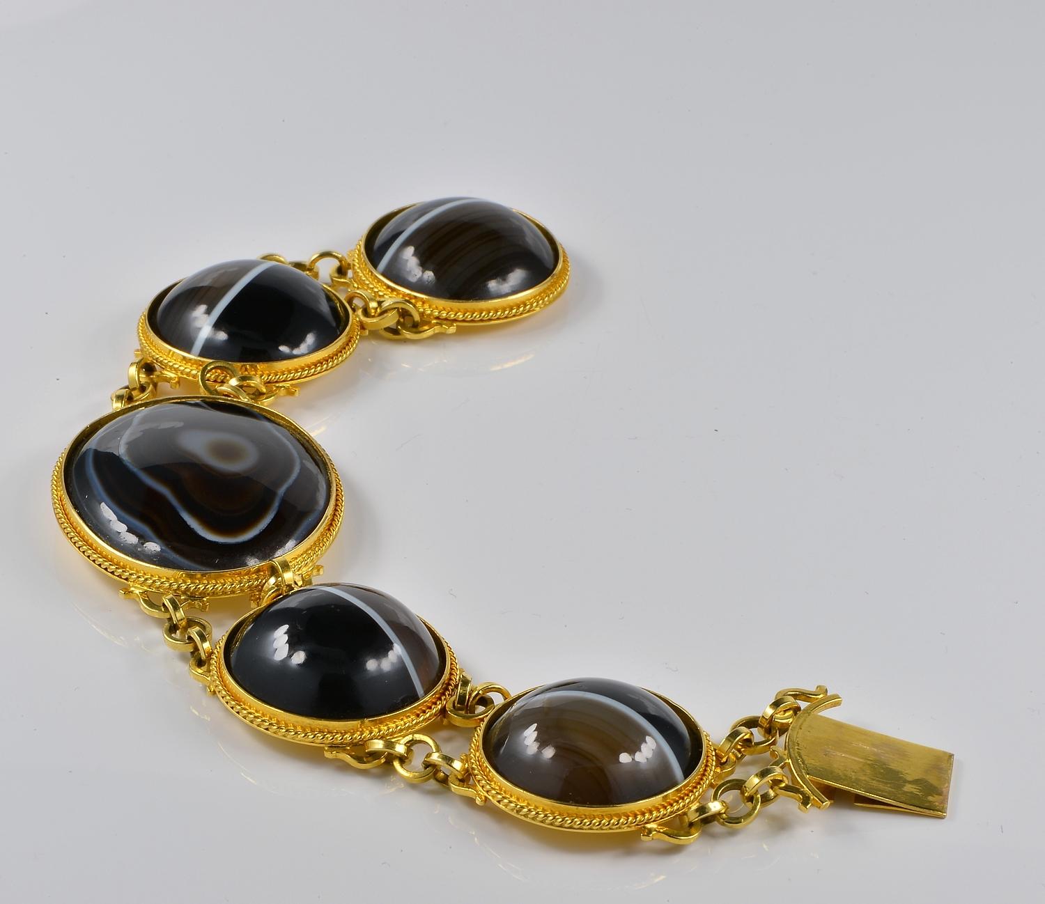 Ce magnifique bracelet est d'époque géorgienne, 1820 env.
Fabriqué à la main en or massif 18 carats
Composé de cinq grands panneaux ovales et ronds sertis de sections d'agate polie à bandes noires.
Merveilleuse exécution présentant chaque panneau