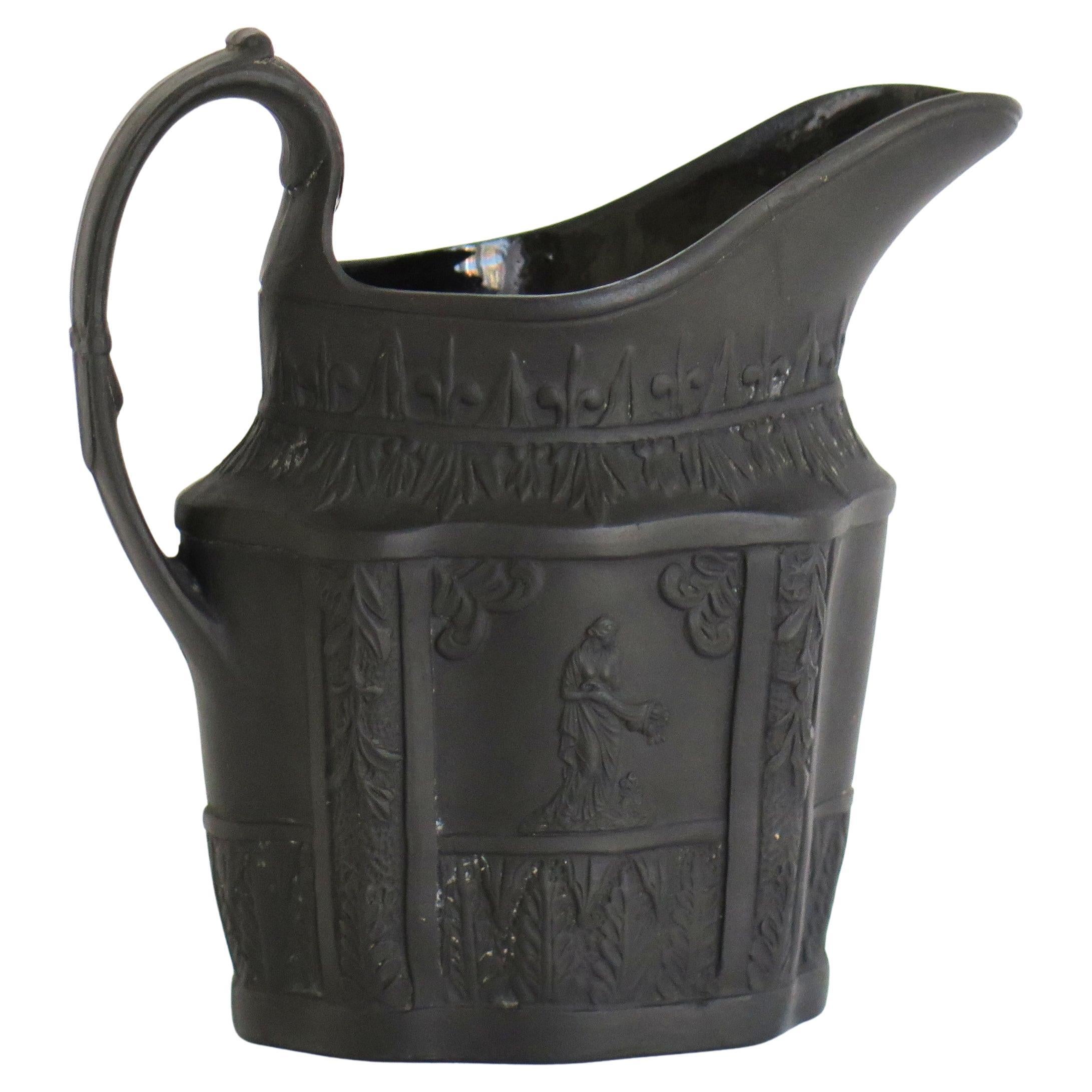 Es handelt sich um einen sehr guten schwarzen Basaltkrug, den wir John Turner aus Lane End, Longton, Staffordshire Potteries, zirka 1762 bis 1806 der englischen Georgianischen Periode, zuschreiben. 

Der Krug hat eine klassische 